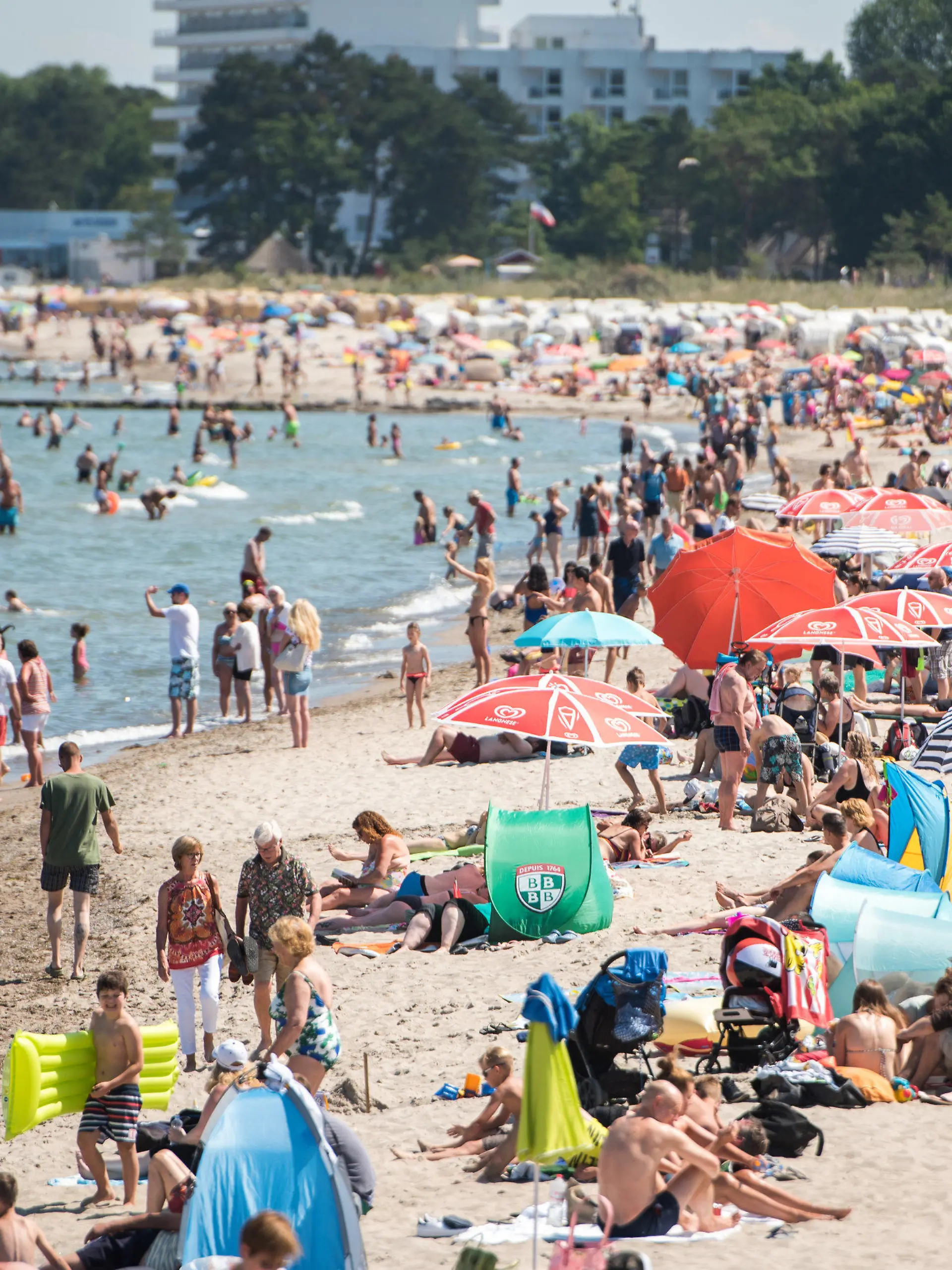 16.07.2018, Schleswig-Holstein, Timmendorfer Strand: Zahlreiche Menschen genießen am Strand und im Wasser der Ostsee das sommerliche Wetter. Foto: Daniel Bockwoldt/dpa +++ dpa-Bildfunk +++
