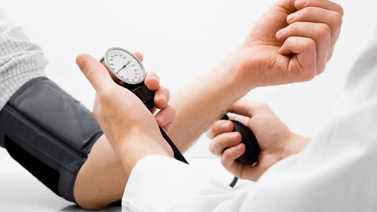 Doctor measuring blood pressure - studio shot on white background