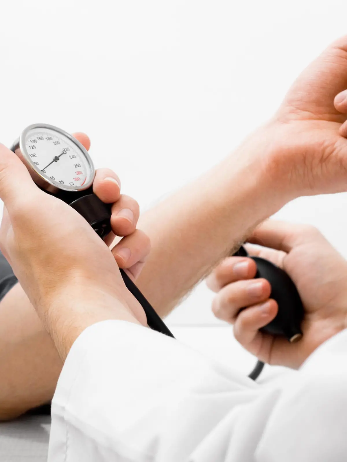 Doctor measuring blood pressure - studio shot on white background