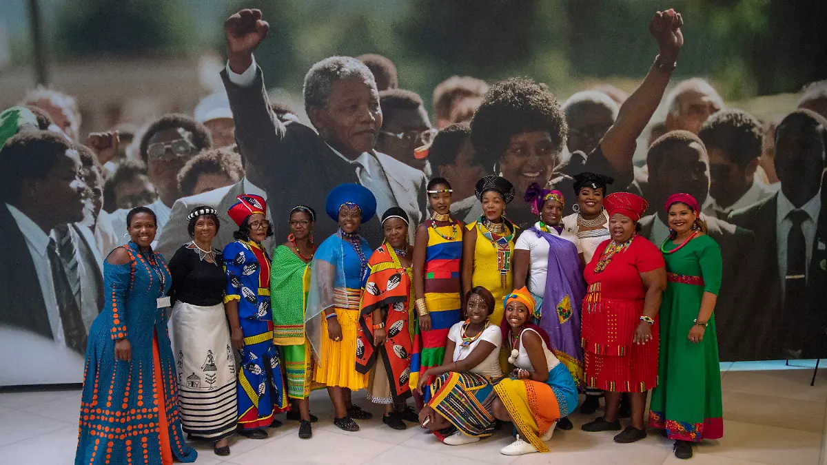 17.07.2018, Großbritannien, London: Ein Chor lässt sich vor einem Bild von Winnie und Nelson Mandela, kurz nach dessen Freilassung, in einer Ausstellung zu Ehren Mandelas fotografieren. Nelson Mandela wurde am 18. Juli 1918 geboren, er starb am 5. Dezember 2013. Die Ausstellung erinnert an dessen Geburtstag vor 100 Jahren und zeigt die Entwicklung des südafrikanischen Freiheitskämpfers. Foto: Arthur Edwards/The Sun pool/AP/dpa +++ dpa-Bildfunk +++
