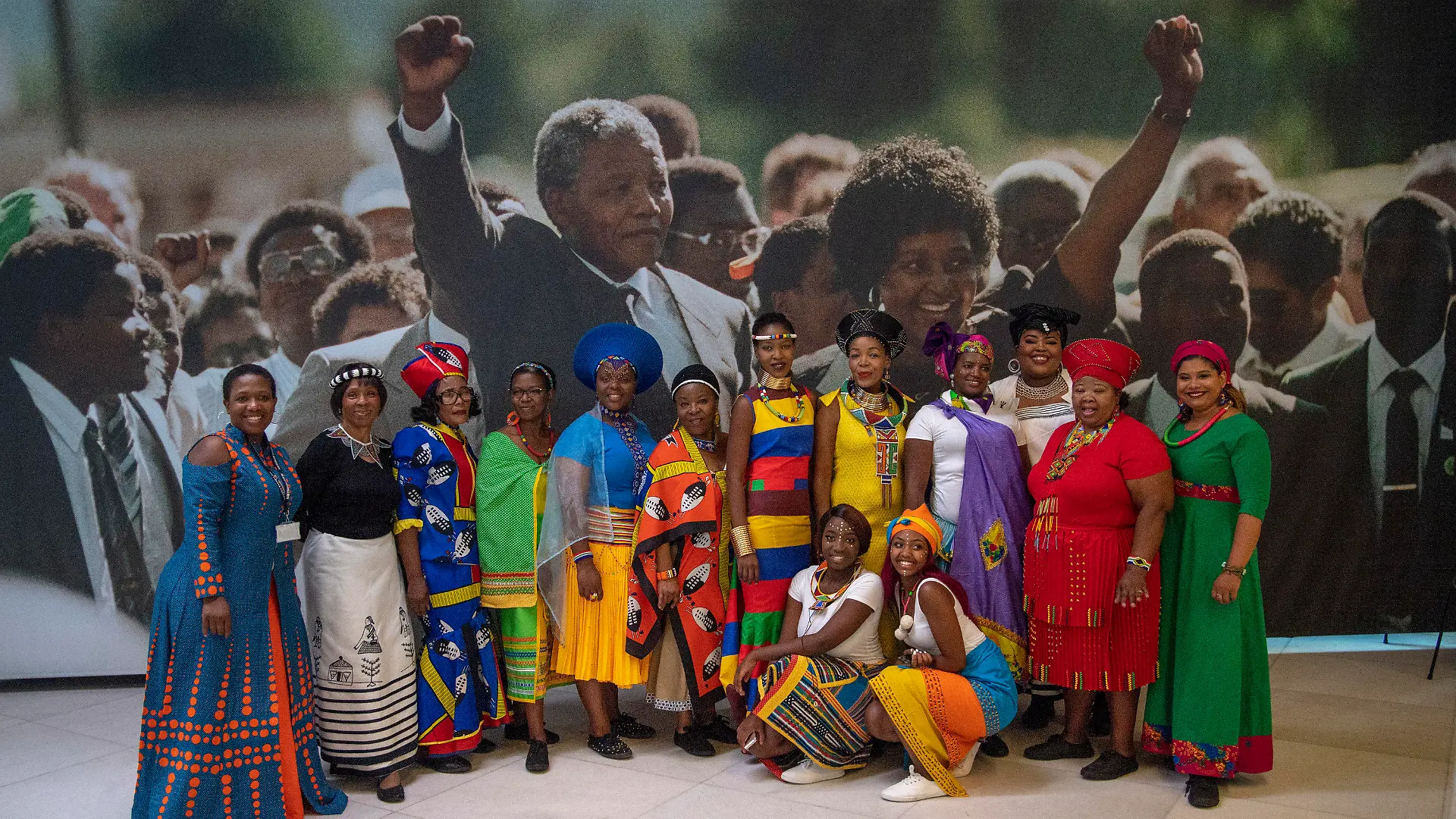 17.07.2018, Großbritannien, London: Ein Chor lässt sich vor einem Bild von Winnie und Nelson Mandela, kurz nach dessen Freilassung, in einer Ausstellung zu Ehren Mandelas fotografieren. Nelson Mandela wurde am 18. Juli 1918 geboren, er starb am 5. Dezember 2013. Die Ausstellung erinnert an dessen Geburtstag vor 100 Jahren und zeigt die Entwicklung des südafrikanischen Freiheitskämpfers. Foto: Arthur Edwards/The Sun pool/AP/dpa +++ dpa-Bildfunk +++