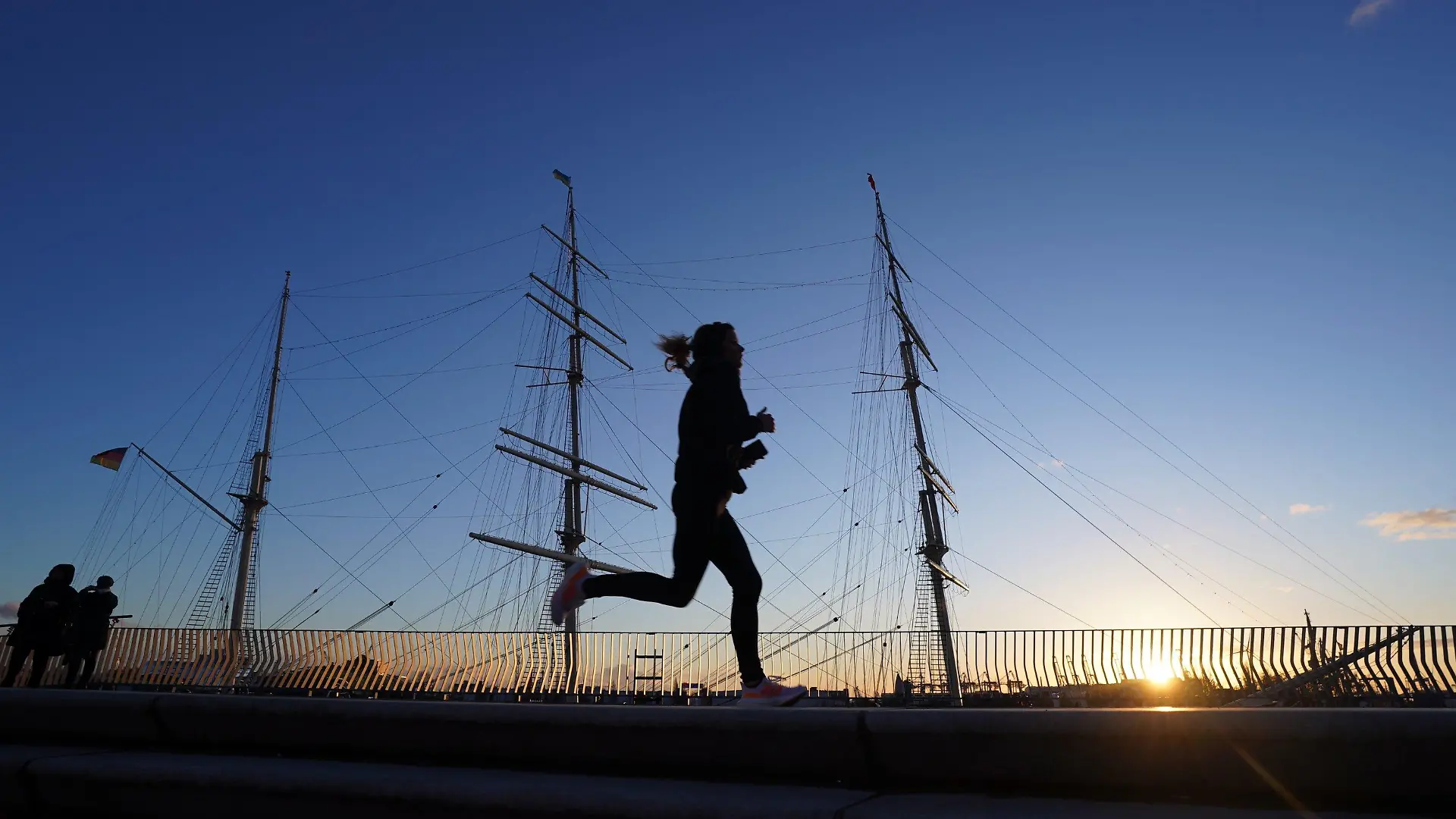 17.01.2023, Hamburg: Eine Joggerin läuft in der Nachmittagssonne an der Rickmer Rickmers im Hafen vorbei. Stürmische Windböen und überfrierende Nässe werden im Norden erwartet. Foto: Marcus Brandt/dpa +++ dpa-Bildfunk +++