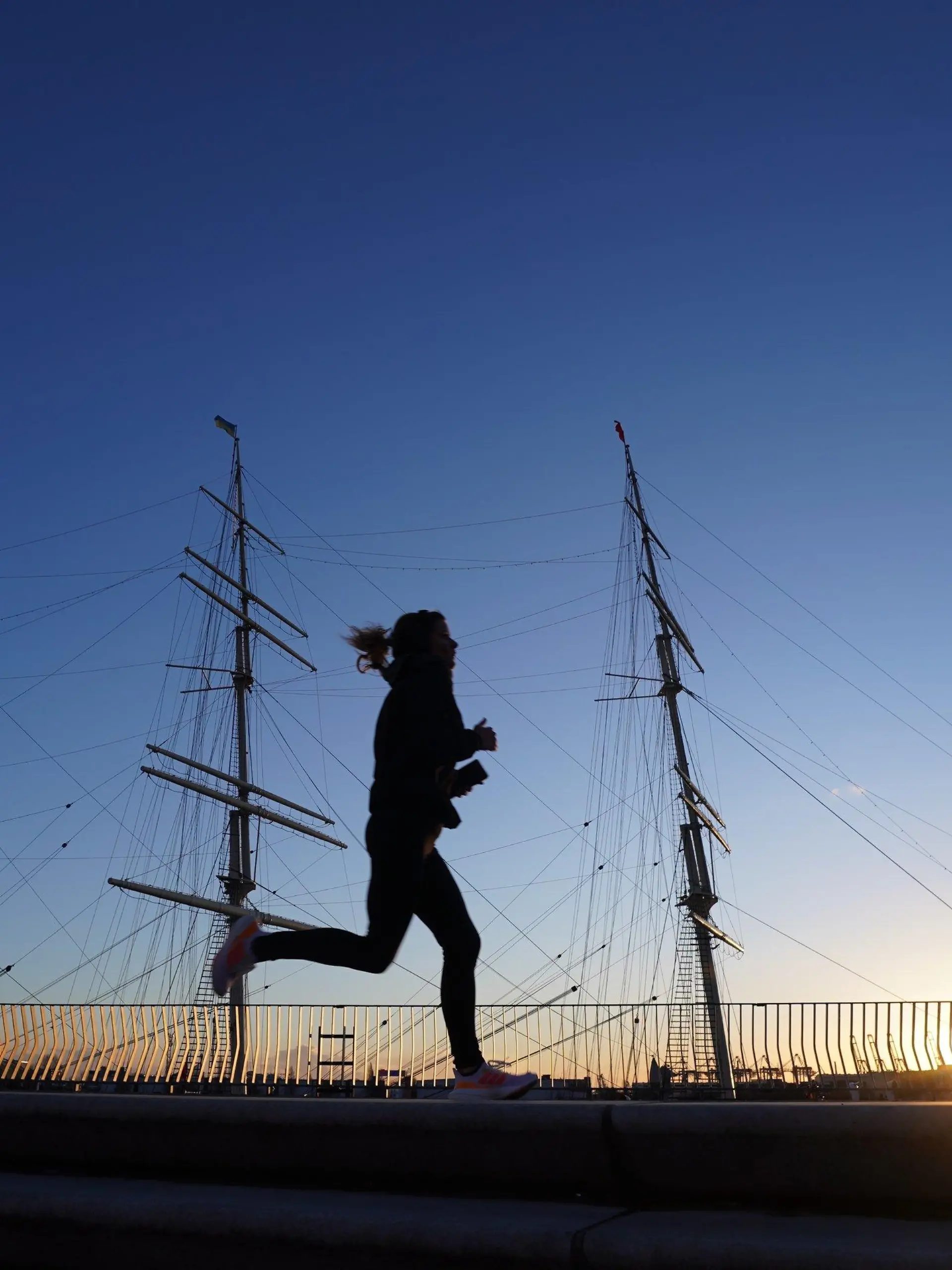 17.01.2023, Hamburg: Eine Joggerin läuft in der Nachmittagssonne an der Rickmer Rickmers im Hafen vorbei. Stürmische Windböen und überfrierende Nässe werden im Norden erwartet. Foto: Marcus Brandt/dpa +++ dpa-Bildfunk +++