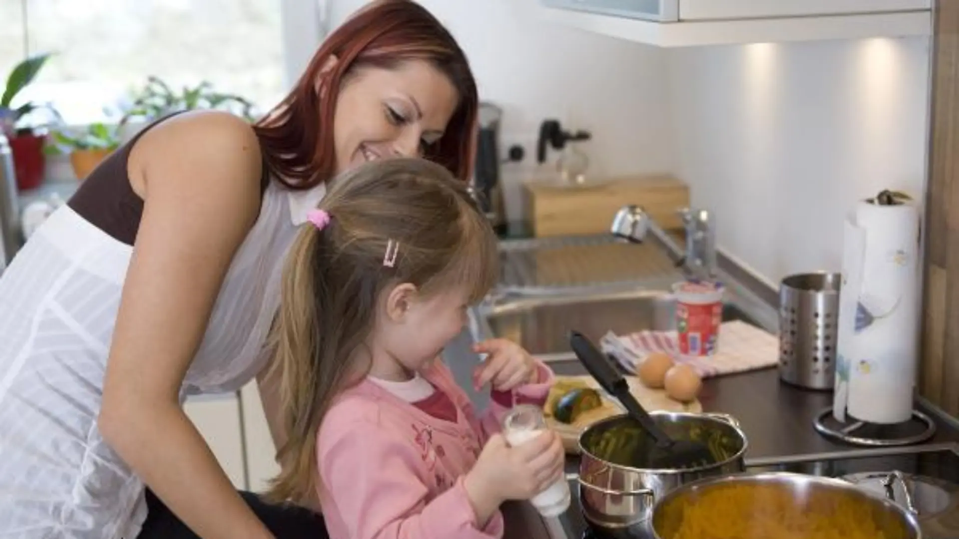 Junge Frauen, Mutter, und Tochter kochen in moderner K¿che - Young woman, mother, and daughter are cooking in modern kitchen