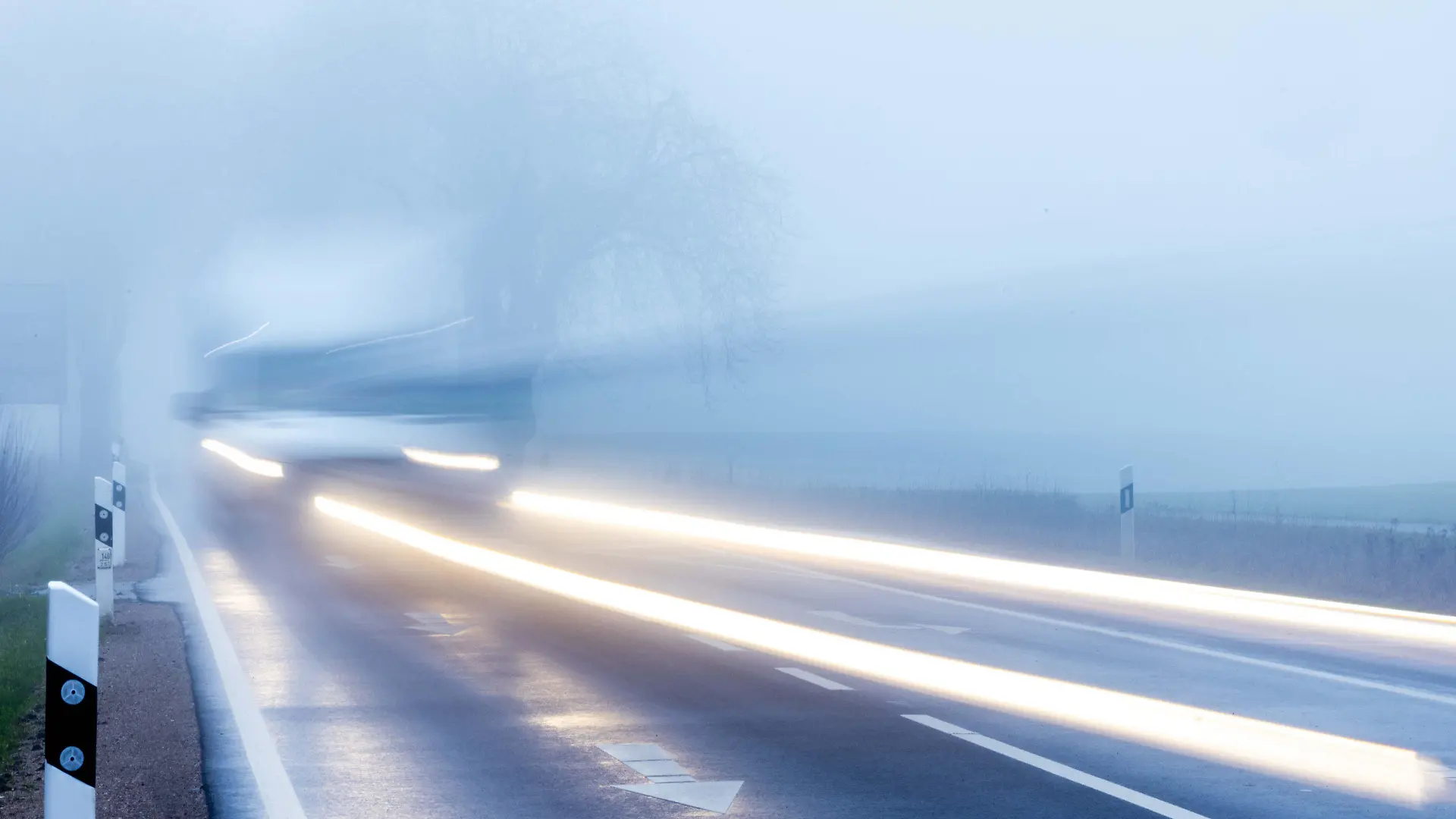 26.01.2023, Mecklenburg-Vorpommern, Mühlen Eichsen: Ein Kleintransporter fährt bei dichtem Nebel durch eine Allee. (Aufnahme mit langer Belichtungszeit) Mit Temperaturen um die null Grad, Nieselregen und teilweise dichtem Nebel zeigt sich das Winterwetter in Norddeutschland von seiner unfreundlichen Seite. Foto: Jens Büttner/dpa +++ dpa-Bildfunk +++