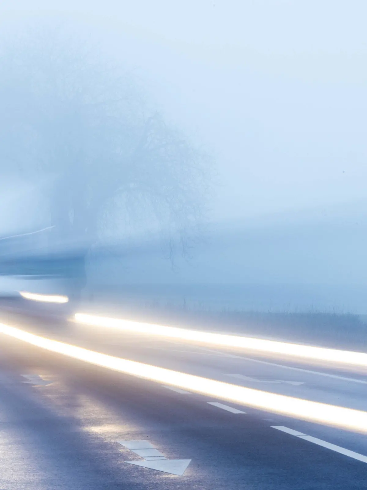 26.01.2023, Mecklenburg-Vorpommern, Mühlen Eichsen: Ein Kleintransporter fährt bei dichtem Nebel durch eine Allee. (Aufnahme mit langer Belichtungszeit) Mit Temperaturen um die null Grad, Nieselregen und teilweise dichtem Nebel zeigt sich das Winterwetter in Norddeutschland von seiner unfreundlichen Seite. Foto: Jens Büttner/dpa +++ dpa-Bildfunk +++