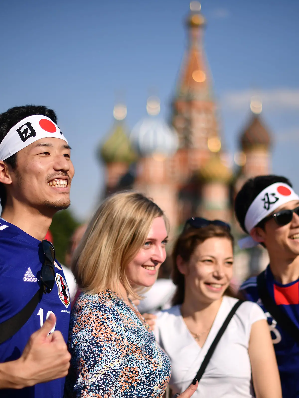MOSCOW, RUSSIA - JUNE 18: Fans of Japan pose with russian women at Moscow Red Square on June 18, 2018 in Moscow, Russia. (Photo by Hector Vivas/Getty Images )
