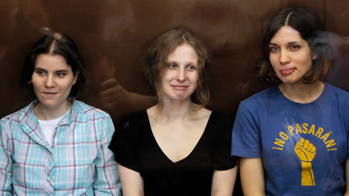 Members of the female punk band "Pussy Riot" (R-L) Nadezhda Tolokonnikova, Maria Alyokhina and Yekaterina Samutsevich sit in a glass-walled cage during a court hearing in Moscow, in this August 17, 2012 file photo. Russian Prime Minister Dmitry Medvedev said on September 12, 2012 he thought three Pussy Riot punk band members should be freed from prison following their conviction last month for a profanity-laced protest against Vladimir Putin in a Moscow cathedral. Picture taken August 17, 2012. REUTERS/Maxim Shemetov/Files (RUSSIA - Tags: CRIME LAW POLITICS RELIGION CIVIL UNREST ENTERTAINMENT)