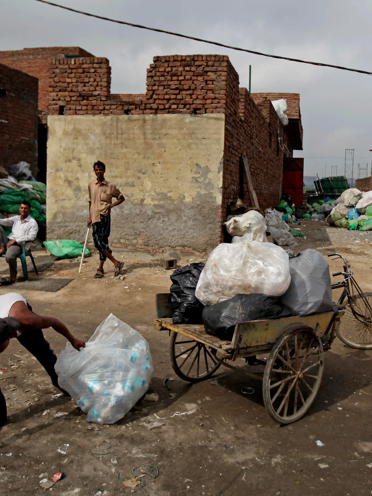 01.06.2018, Indien, Neu Delhi: Ein Mann sammelt benutzte Plastikflaschen. Indien produziert täglich 69 Millionen Tonnen Müll. Mehr als 17,000 Tonnen davon ist Plastik. Das erfordert riesige Müllhalden, welche bis zu 50 Meter hohe, stinkende Müllberge in Städten wie Neu Delhi zur Folge haben. Zum Tag der Umwelt am 5. Juni wollen Naturschützer das Bewusstsein für den Umgang mit Plastik schärfen. Foto: Altaf Qadri/AP/dpa +++ dpa-Bildfunk +++
