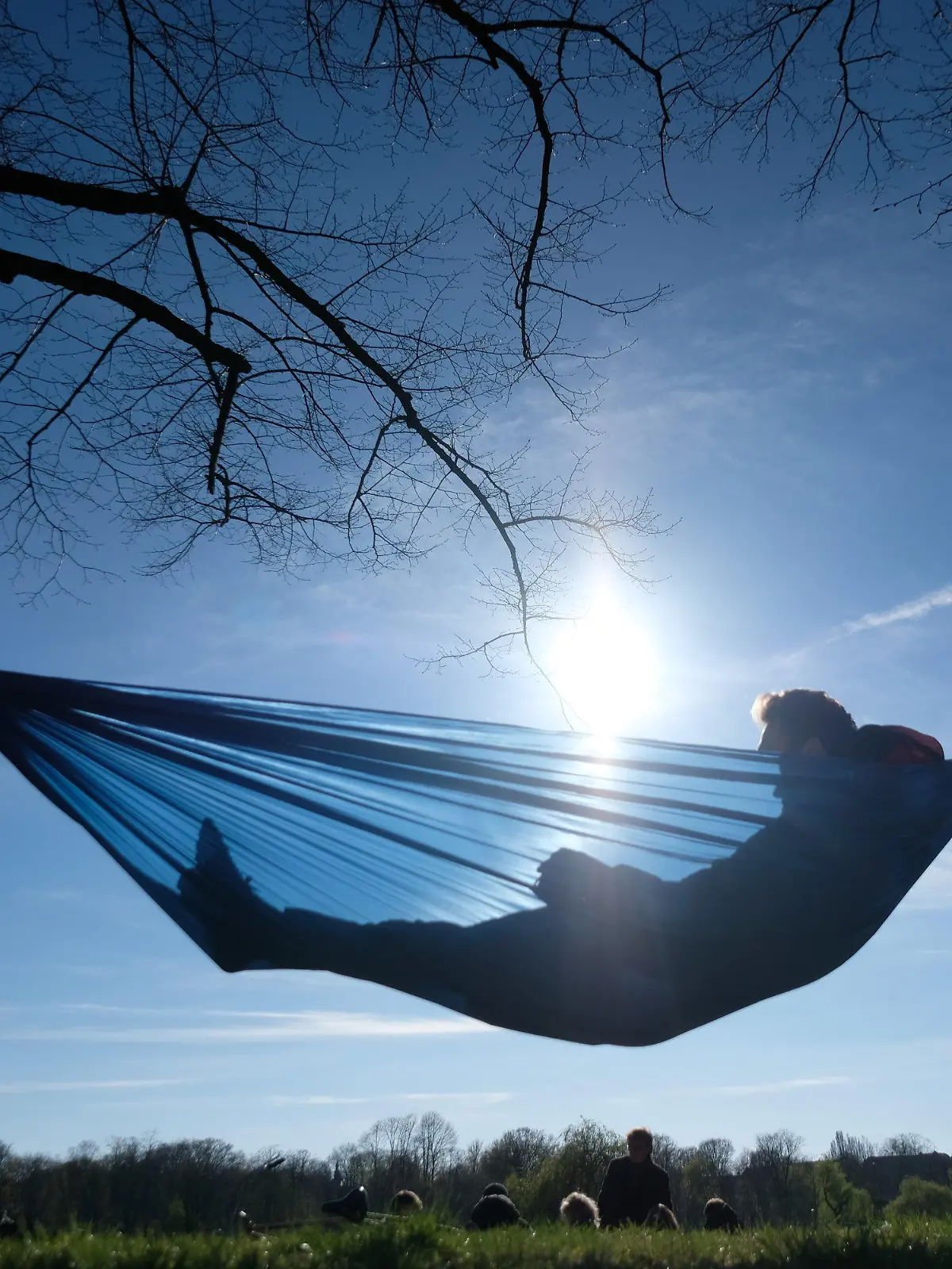 16.04.2022, Leipzig, Sachsen: Ein junger Mann liegt im Palmengarten in einer Hängematte. Das Wetter des Osterwochenendes in Mitteldeutschland gestaltet sich mit einem Mix aus Wolken und Sonne. Foto: Sebastian Willnow/dpa +++ dpa-Bildfunk +++