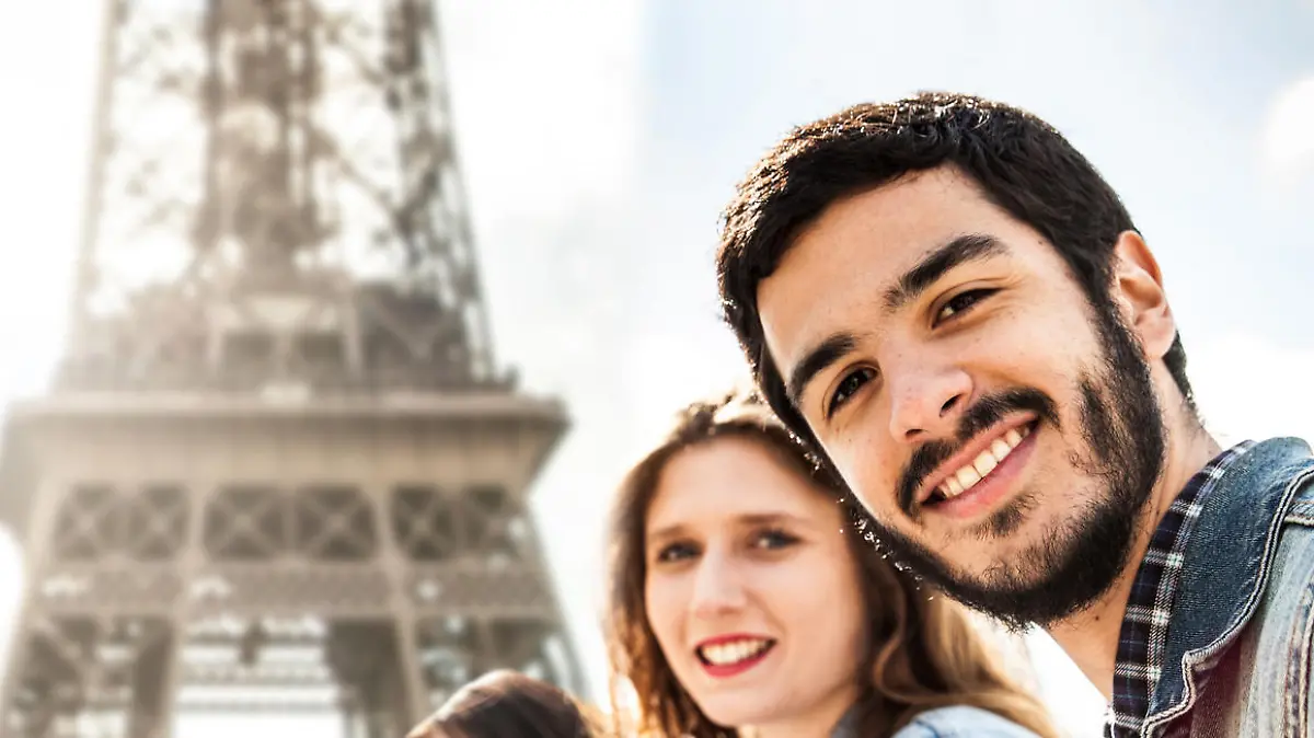 Students on travel in Paris - Tour Eiffel with teacher having an outdoor lesson during a field trip in Europe.