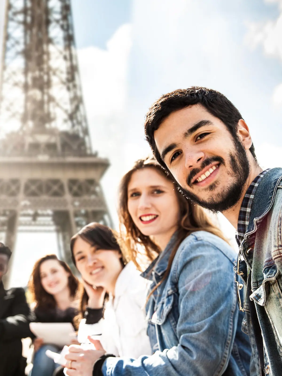 Students on travel in Paris - Tour Eiffel with teacher having an outdoor lesson during a field trip in Europe.