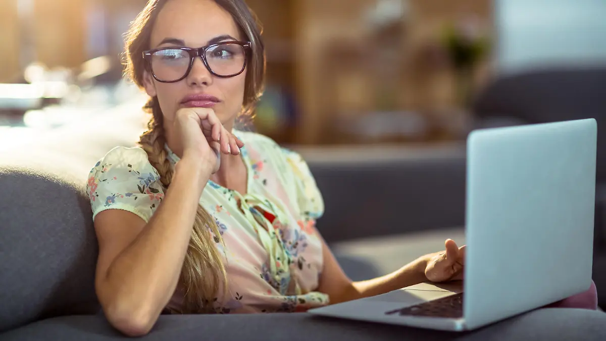 Frau sitzt nachdenklich vor ihrem Laptop