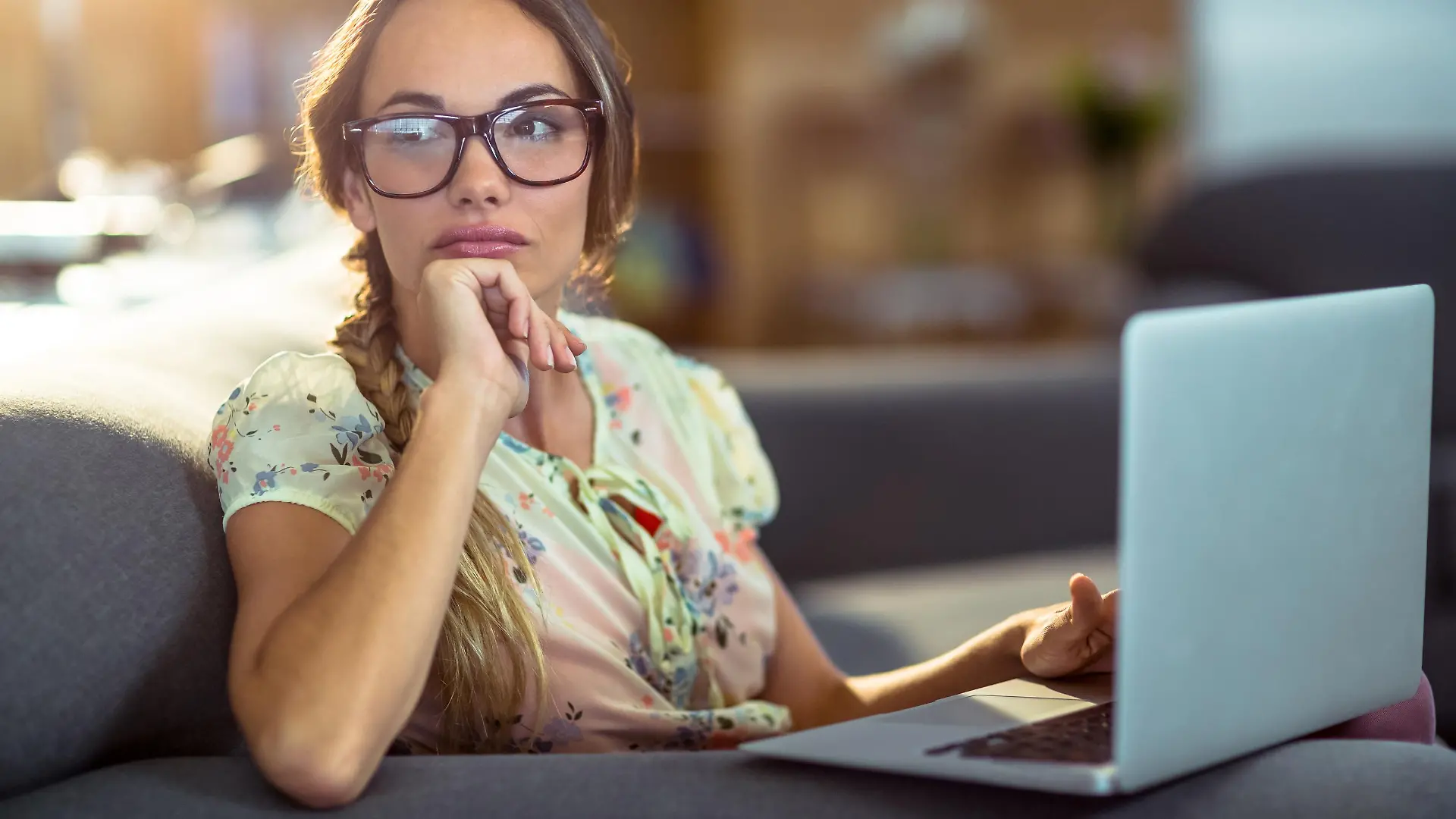 Frau sitzt nachdenklich vor ihrem Laptop