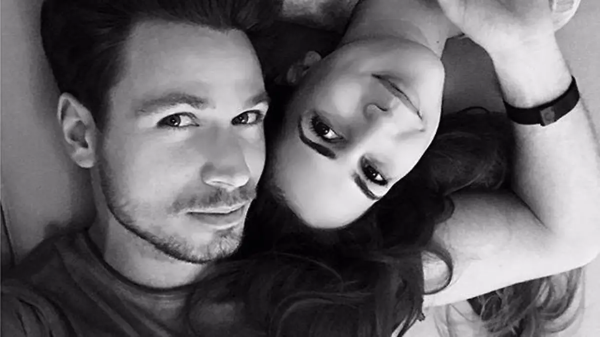 Sebastian Pannek und Clea-Lacy Juhn liegen auf dem Bett und halten Händchen