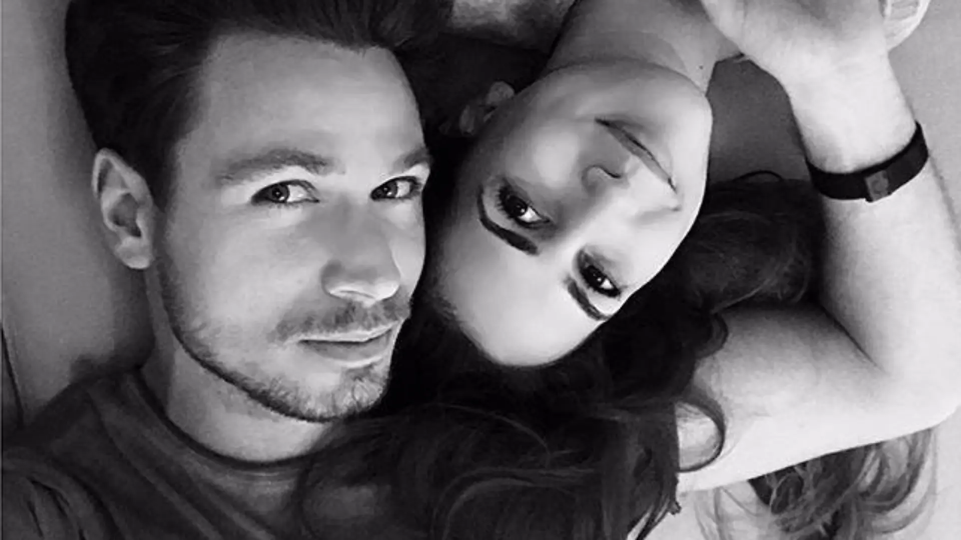 Sebastian Pannek und Clea-Lacy Juhn liegen auf dem Bett und halten Händchen