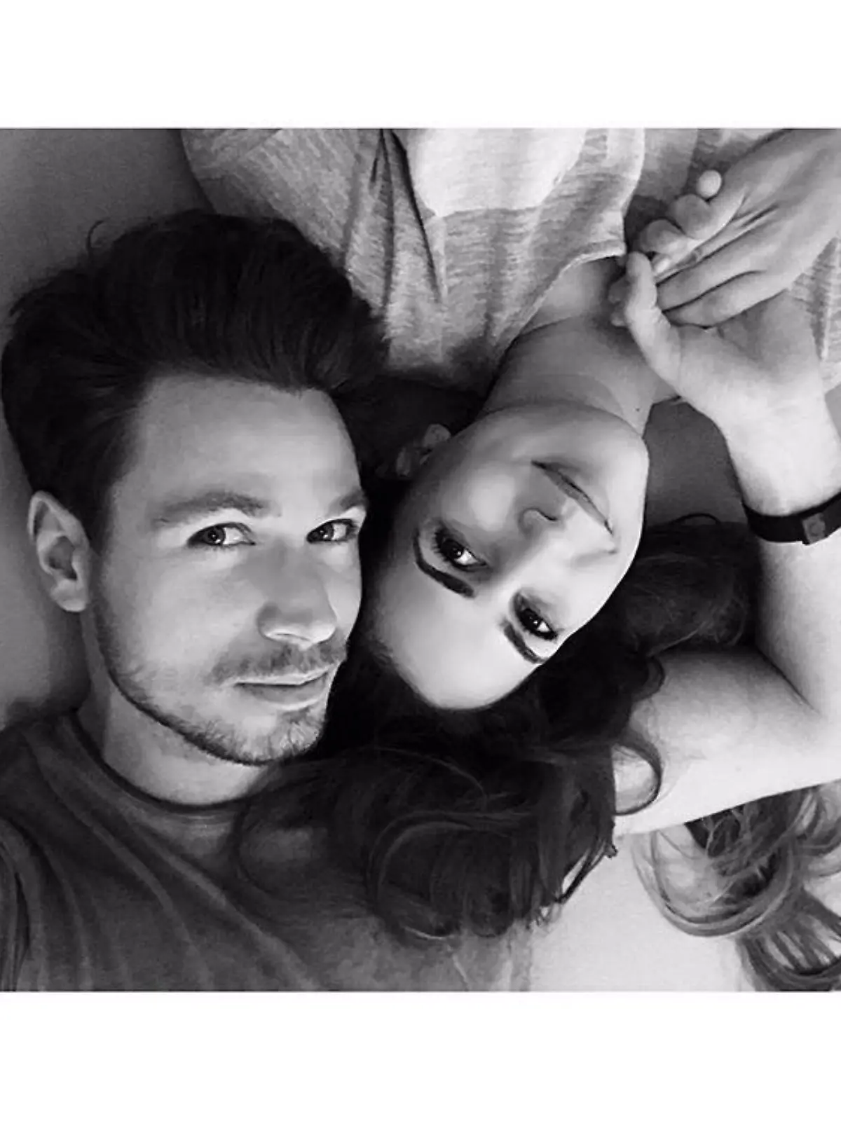 Sebastian Pannek und Clea-Lacy Juhn liegen auf dem Bett und halten Händchen