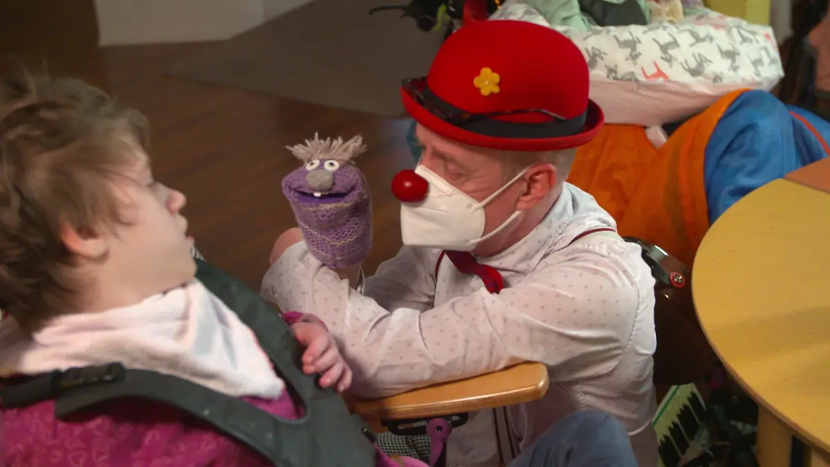 Der Clown Petersilie lässt seine Handpuppe für die 14-jährige Patientin Masa ein Lied singen.