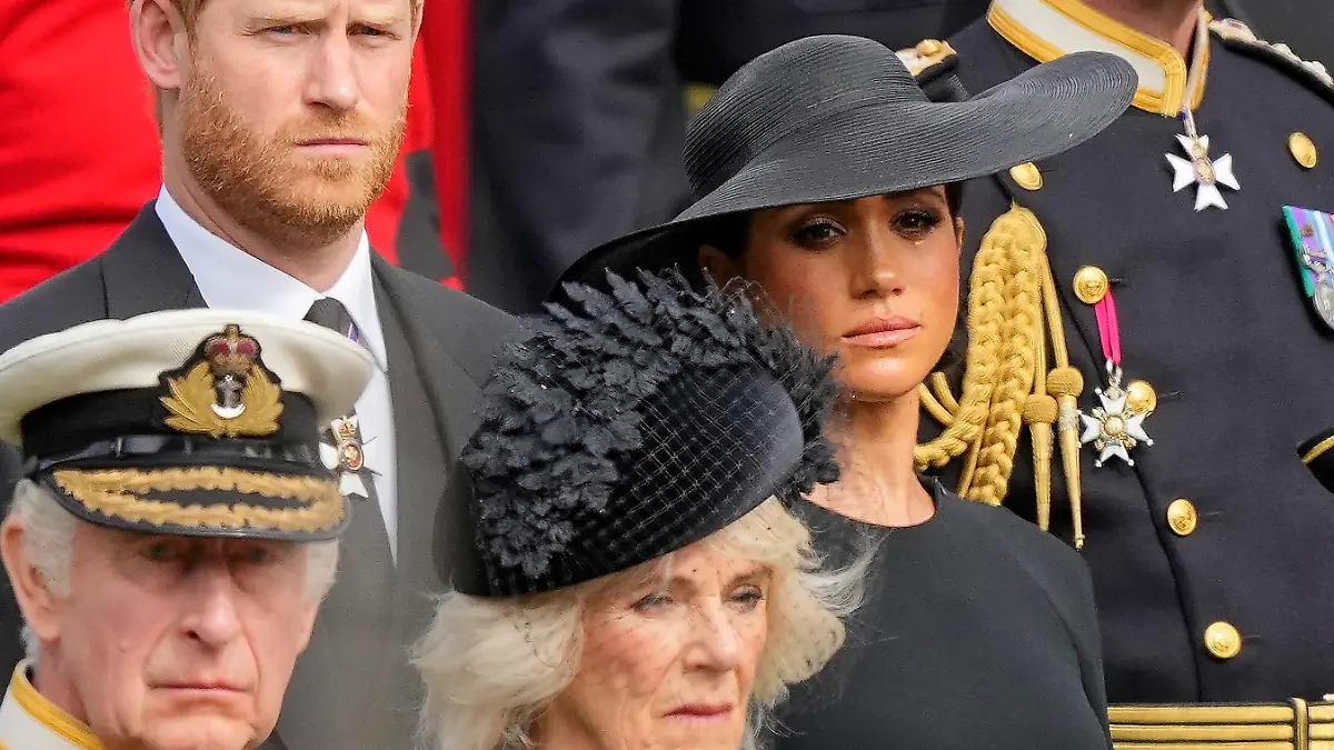 ARCHIV - 19.09.2022, Großbritannien, London: König Charles III. (vorn), Königsgemahlin Camilla, Prinz Harry, Herzog von Sussex, (dahinter), und seine Frau Meghan, Herzogin von Sussex, schauen auf den Trauerzug mit dem Sarg der gestorbenen britischen Königin Elizabeth II. auf dem als Lafette bezeichnete Kanonenwagen. Die im Schatten sieht man nicht? Das legt jedenfalls der Titel von Prinz Harrys Autobiografie nahe. «Reserve» soll zwar erst im Januar erscheinen. Doch für Aufregung in seiner Heimat Großbritannien sorgt das Buch schon jetzt. (zu dpa «Nur «Reserve»? Memoiren von Harry sorgen für Zoff im Königreich») Foto: Martin Meissner/Pool AP/dpa +++ dpa-Bildfunk +++