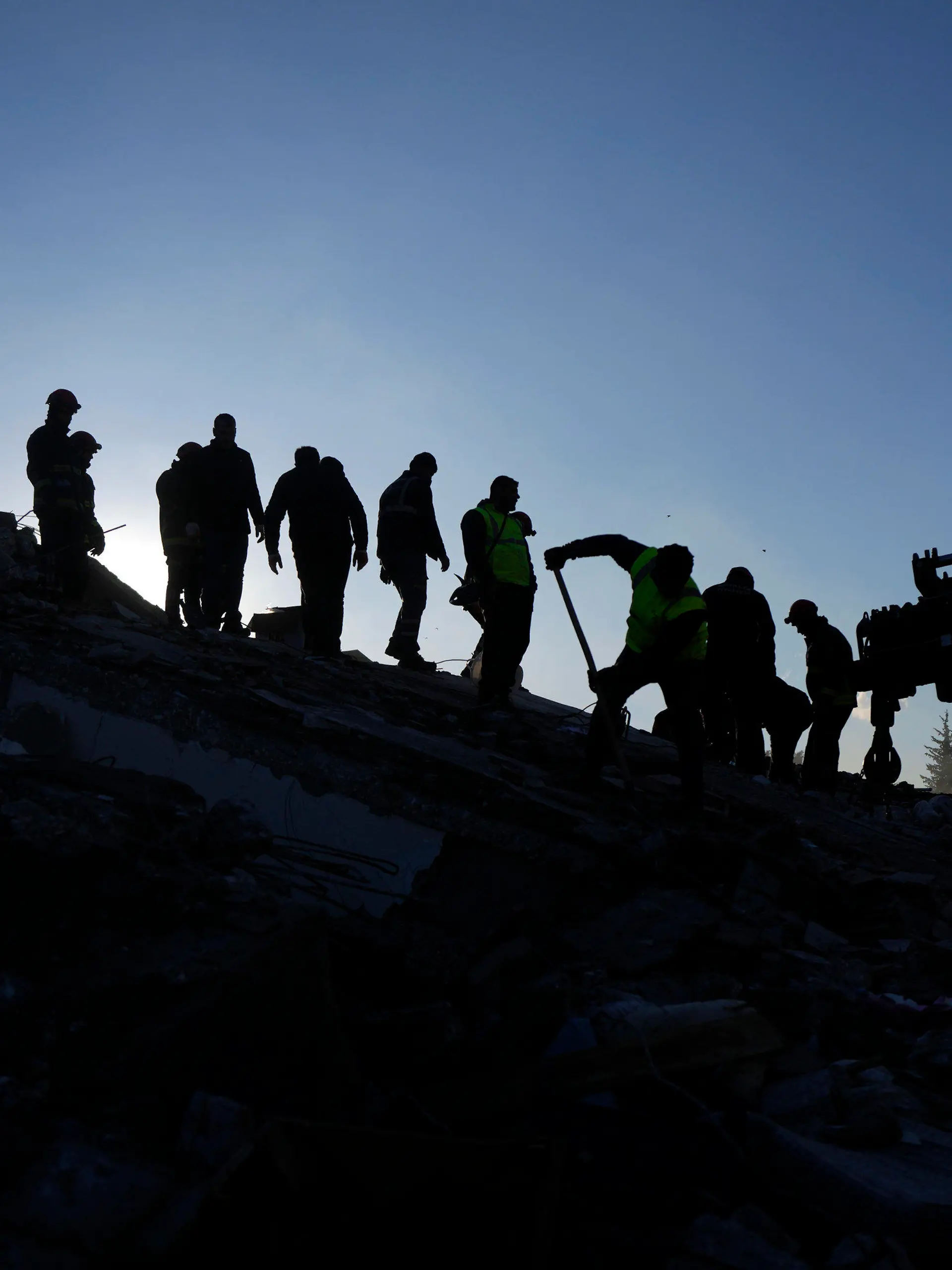 08.02.2023, Türkei, Antakya: Rettungsteams suchen nach Menschen in den Trümmern zerstörter Gebäude. In den Erdbeben-Gebieten in Syrien und der Türkei werden bei der Suche nach Verschütteten immer mehr Leichen aus den Resten eingestürzter Gebäude geborgen. Mehrfach korrigierten die türkischen Behörden am Mittwoch die Zahl bestätigter Opfer nach oben. Foto: Khalil Hamra/AP/dpa +++ dpa-Bildfunk +++