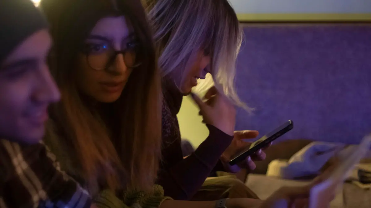 An Iranian young woman uses her smartphone to check her social media pages while waiting for an underground music performance at a cafe in downtown Tehran at night, January 18, 2023. Tehran seems more calm after months of unrest, with youths gathering at cafes, playing music and socializing. (Photo by Morteza Nikoubazl/NurPhoto)