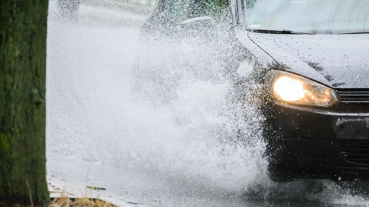 23.06.2023, Niedersachsen, Hannover: Ein Auto fährt durch eine große Regenpfütze an der Hildesheimer Straße. Foto: Julian Stratenschulte/dpa +++ dpa-Bildfunk +++