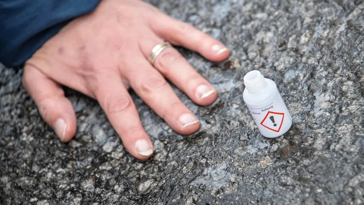 Klimakleber blockieren den Verkehr auf der Sonnenstraße, Nahaufnahme einer festgeklebten Hand, Protestaktion der Letzten Generation, München, 20.12.2022 Deutschland, München, 20.12.2022, zwei Klima-Aktivisten der Letzten Generation haben sich auf der Sonnenstraße festgeklebt, Nahaufnahme einer auf dem Asphalt festgeklebten Hand, leeres Fläschchen mit Sekundenkleber, Straßenblockade im morgendlichen Berufsverkehr, Aktion startete am Dienstagmorgen um 8:20 Uhr früh, die Stadt München hatte solche Aktionen der Letzten Generation per Allgemeinverfügung untersagt, Umwelt, Aktion, Protest, *** Climate stickers block traffic on Sonnenstraße, closeup of a stuck hand, Last Generation protest action, Munich, 20 12 2022 Germany, Munich, 20 12
