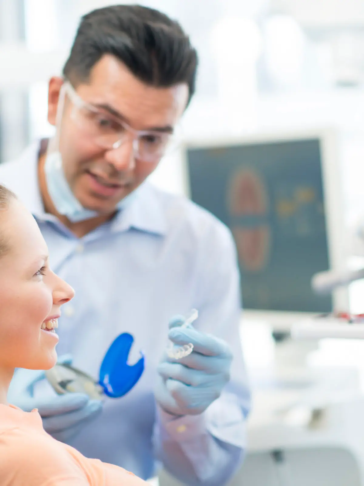 A young female (teenager) at the dentists office in a dental chair receiving her new invisalign braces.