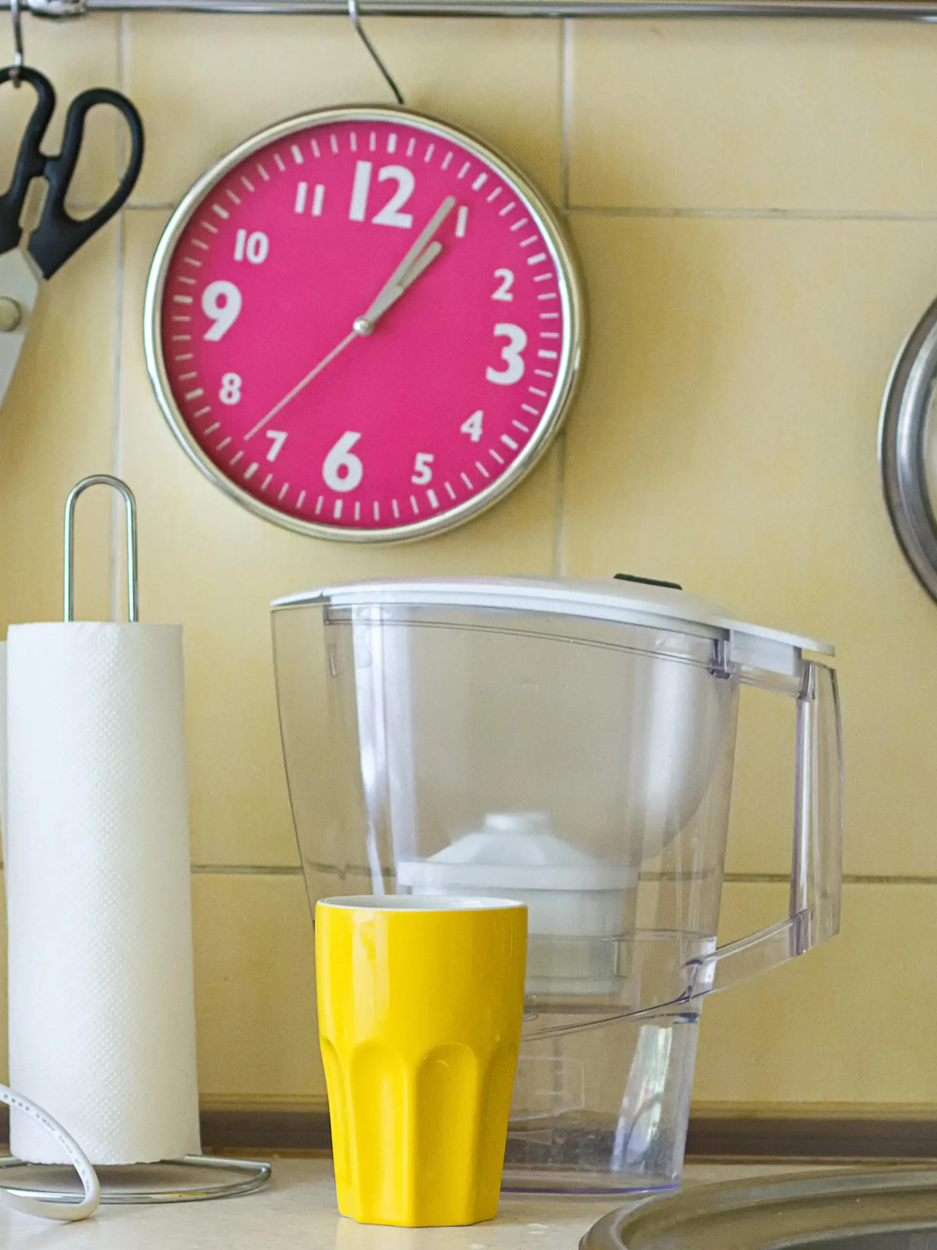 Kitchen table with water filter, clock, paper napkins
