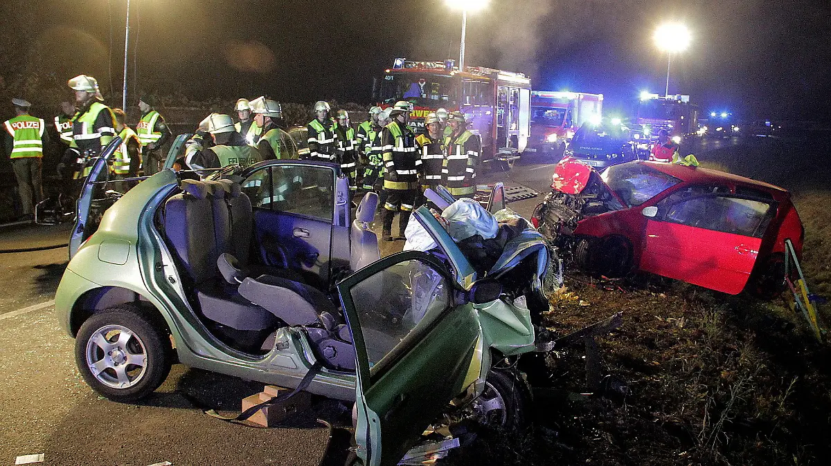ARCHIV - 20.11.2016, Bayern, Rosenheim: Rettungskräfte und zwei zerstörte Fahrzeuge stehen an einer Unfallstelle. Zwei junge Frauen starben bei dem Unfall, drei Menschen wurden schwer verletzt. Nun müssen sich zwei Männer wegen fahrlässiger Tötung vor Gericht verantworten. (zu dpa «Neuauflage des Prozesses um einen tödlichen Verkehrsunfall» vom 10.04.2018) Foto: Josef Reisner/dpa +++ dpa-Bildfunk +++