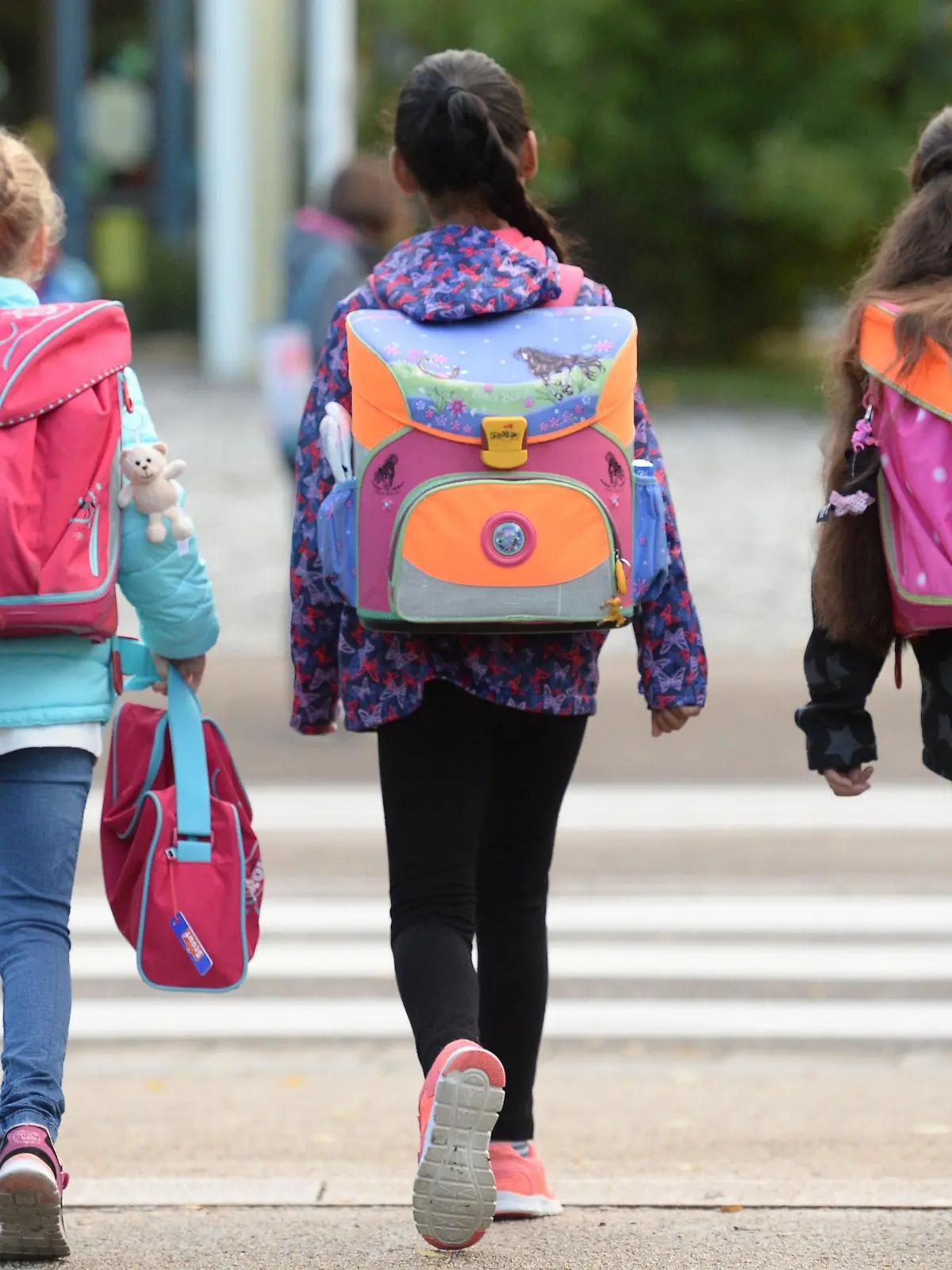 ARCHIV - 14.09.2015, Baden-Württemberg, Freiburg: Drei Schülerinnen laufen mit ihren Schulranzen zur Schule.   (zu dpa vom 07.04.2018: Mit «Früben» entspannt in den Alltag: Schulen testen flexiblen Beginn) Foto: Patrick Seeger/dpa +++ dpa-Bildfunk +++