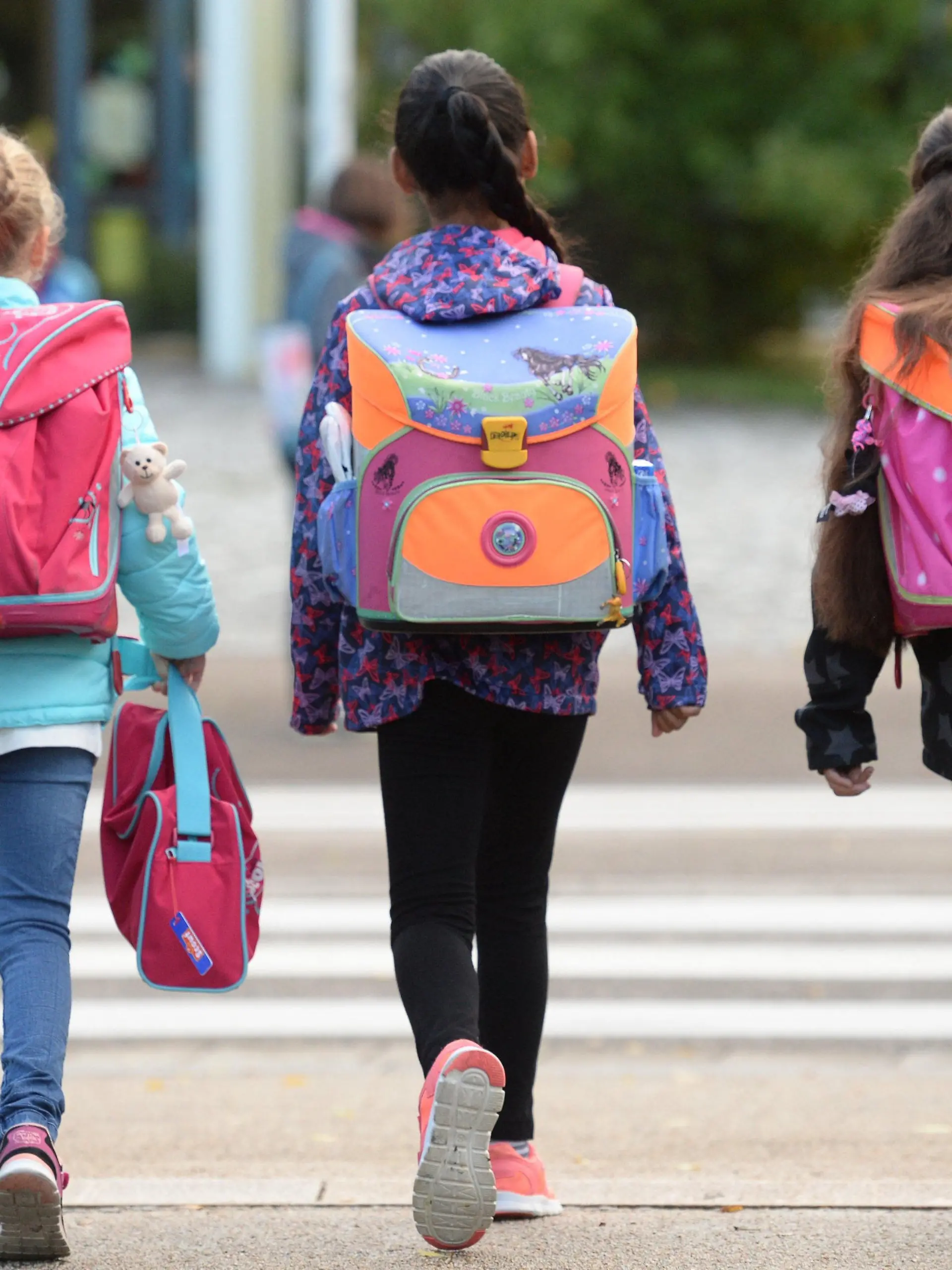 ARCHIV - 14.09.2015, Baden-Württemberg, Freiburg: Drei Schülerinnen laufen mit ihren Schulranzen zur Schule.   (zu dpa vom 07.04.2018: Mit «Früben» entspannt in den Alltag: Schulen testen flexiblen Beginn) Foto: Patrick Seeger/dpa +++ dpa-Bildfunk +++