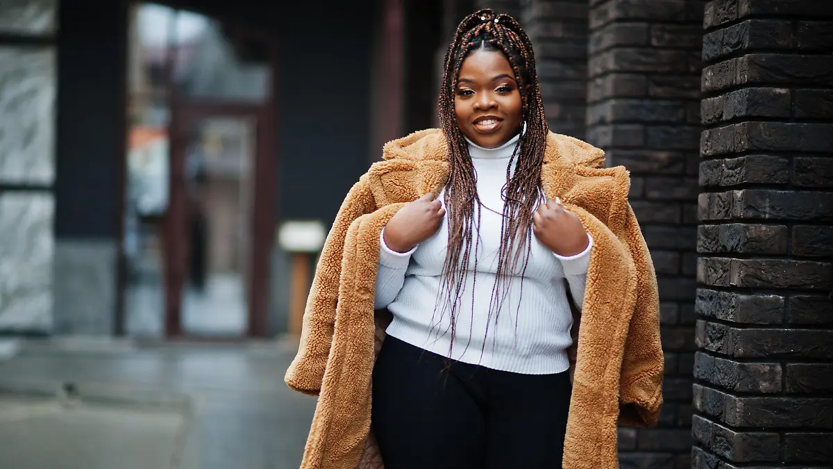 Glamorous african american woman in warm fur coat pose at street.