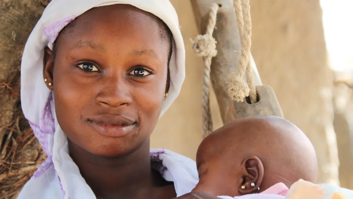 20.03.2018, Mali, M'Pentièrébougou: Die 13-jährige Minata, die schon im Alter von zwölf Jahren verheiratet wurde, hält im Hof ihres Elternhauses in der Region Koulikoro im Zentrum Malis ihre etwa zweieinhalb Monate alte Tochter Dioulaba im Arm. (zu dpa «Kleine Mädchen als Bräute: «Ich habe Angst, schwanger zu werden»» vom 07.04.2018) Foto: Jürgen Bätz/dpa +++ dpa-Bildfunk +++