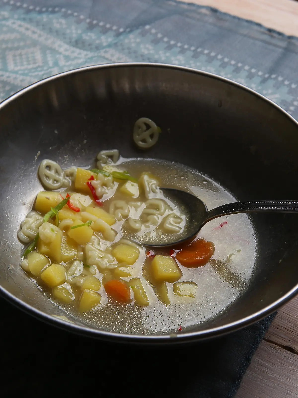 Pasta soup in metal bowl.