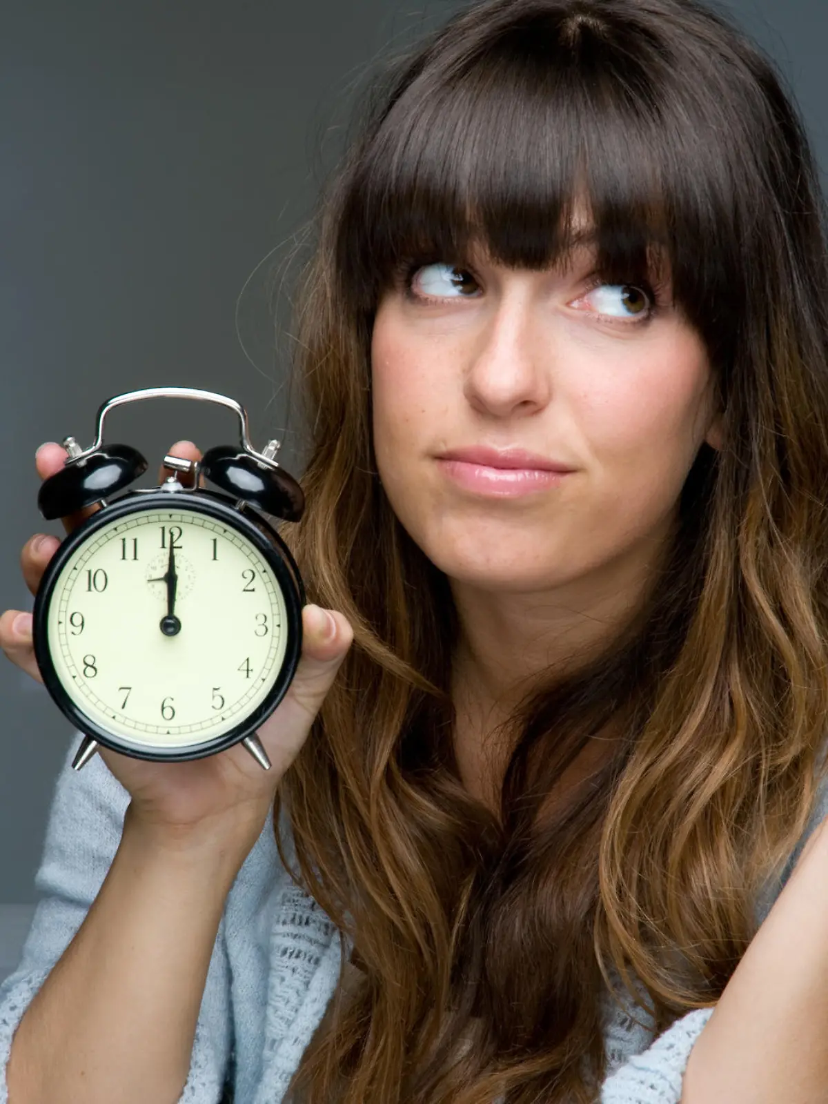 Woman with clock looking frustrated