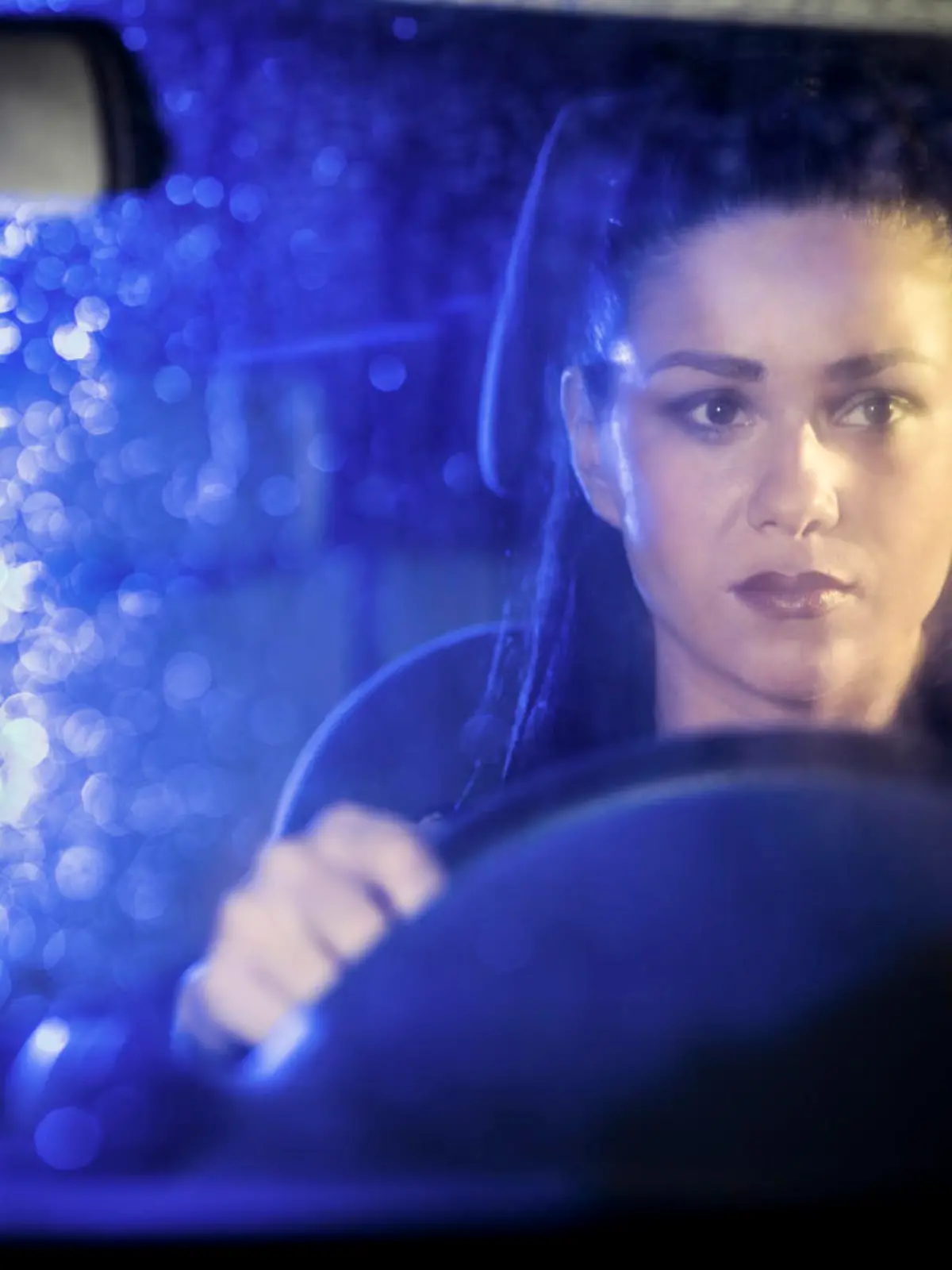Frau fährt Auto bei Nacht.