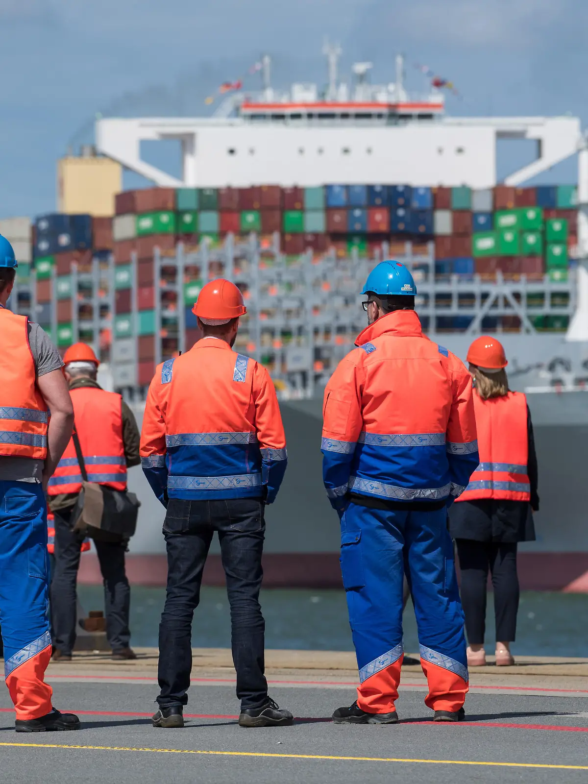 Der Containerschiff-Neubau MV «OOCL Hong Kong» läuft am 02.07.2017 erstmalig den JadeWeserPort in Wilhelmshaven (Niedersachsen) an. Das mit einer Länge von rund 400 Metern und einer Breite von 59 Metern weltgrößte Containerschiff gehört zu dem neu gegründeten Reeder-Großverbund «Ocean Alliance», dessen Schiffe seit Mai wöchentlich Deutschlands einzigen Tiefwasserhafen anlaufen. Journalisten und Eurogate-Mitarbeiter erwarten den Riesen auf der Pier stehend. Foto: Ingo Wagner/dpa ++