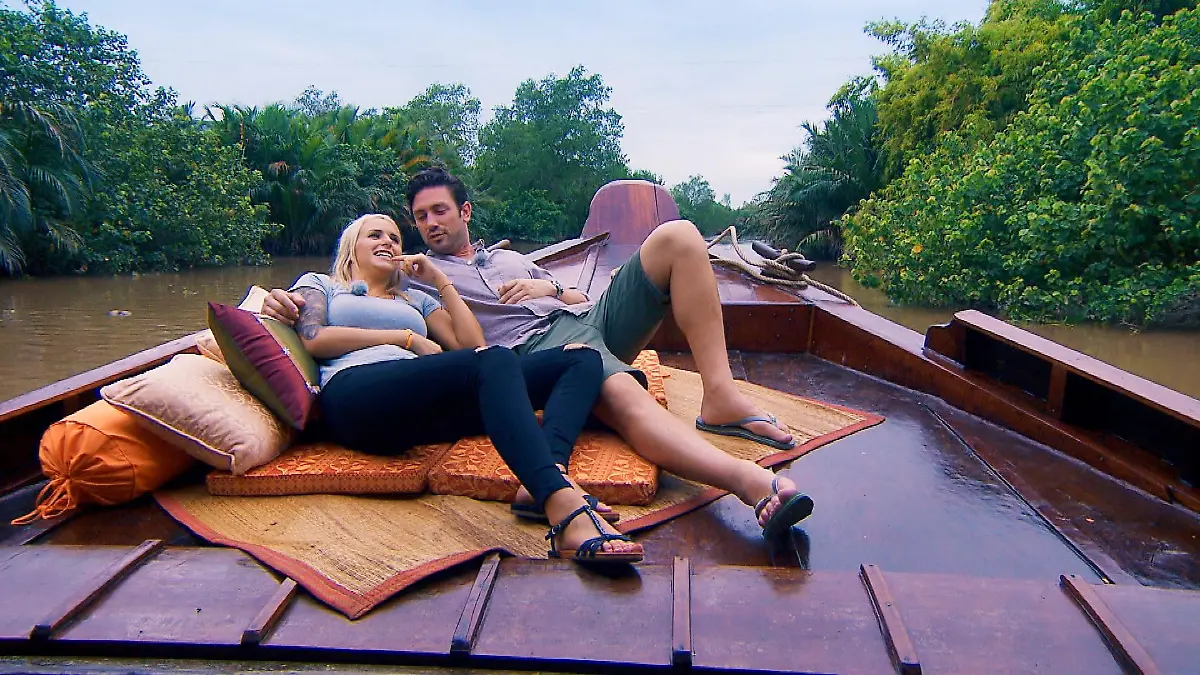 In einem landestypischen Boot geht es für Carina und Daniel über den Mekong-Fluss.
