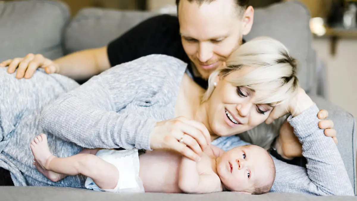 Family with one day son (0-1 months) lying on sofa, Familie mit ein Tag altes Baby (0-1 Monate), auf der Couch liegen | Verwendung weltweit, Keine Weitergabe an Wiederverkäufer.