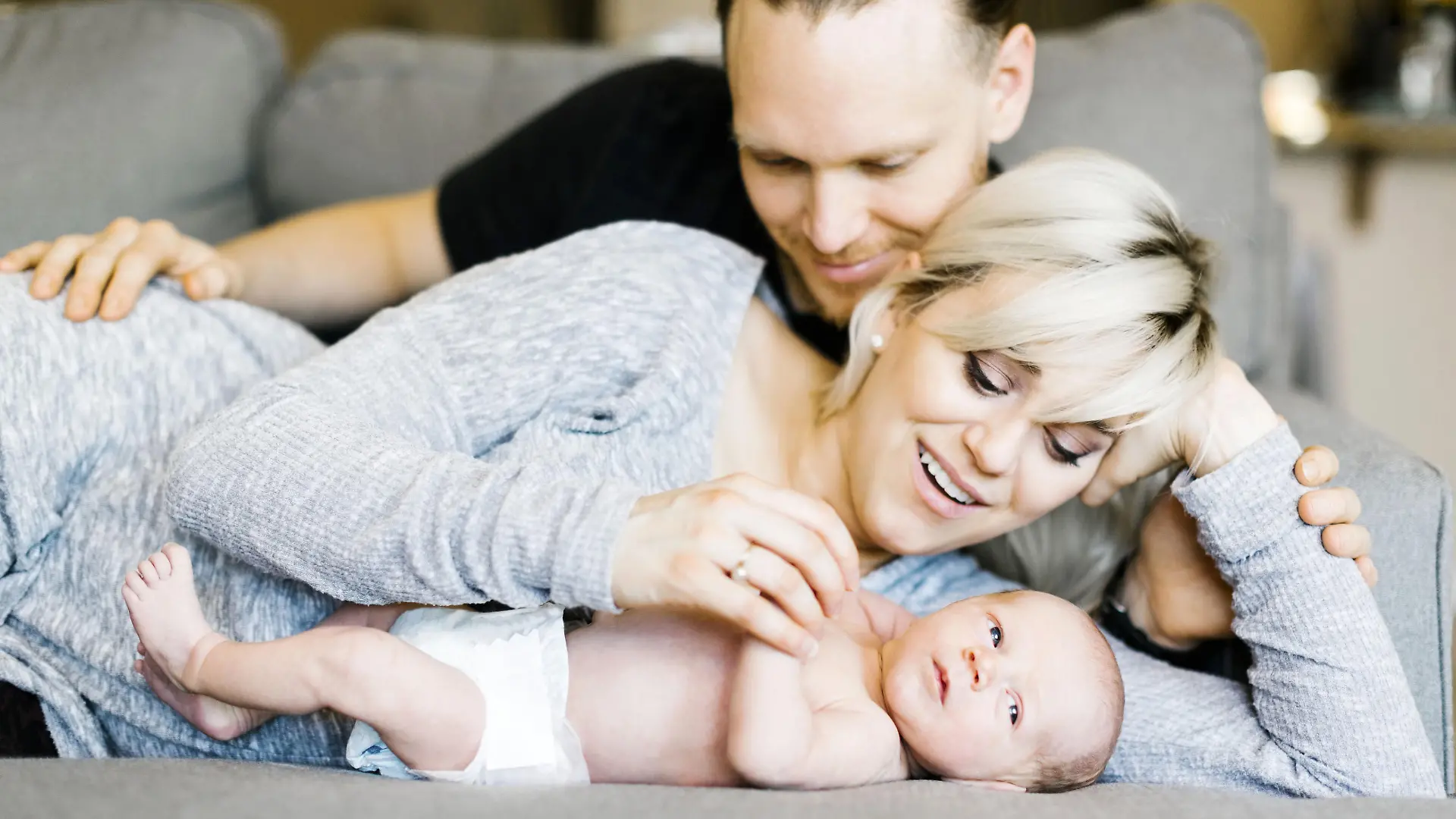 Family with one day son (0-1 months) lying on sofa, Familie mit ein Tag altes Baby (0-1 Monate), auf der Couch liegen | Verwendung weltweit, Keine Weitergabe an Wiederverkäufer.