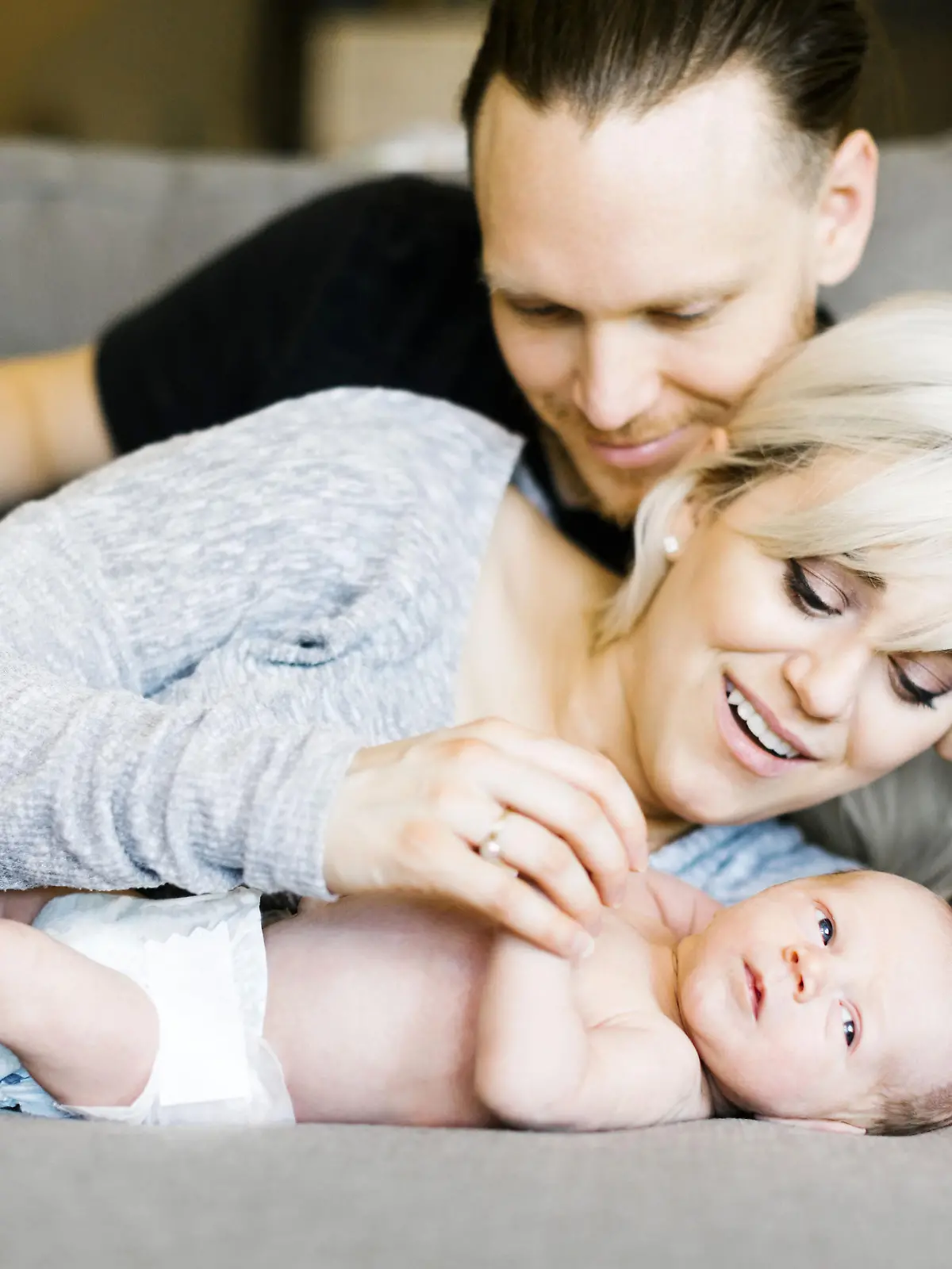 Family with one day son (0-1 months) lying on sofa, Familie mit ein Tag altes Baby (0-1 Monate), auf der Couch liegen | Verwendung weltweit, Keine Weitergabe an Wiederverkäufer.