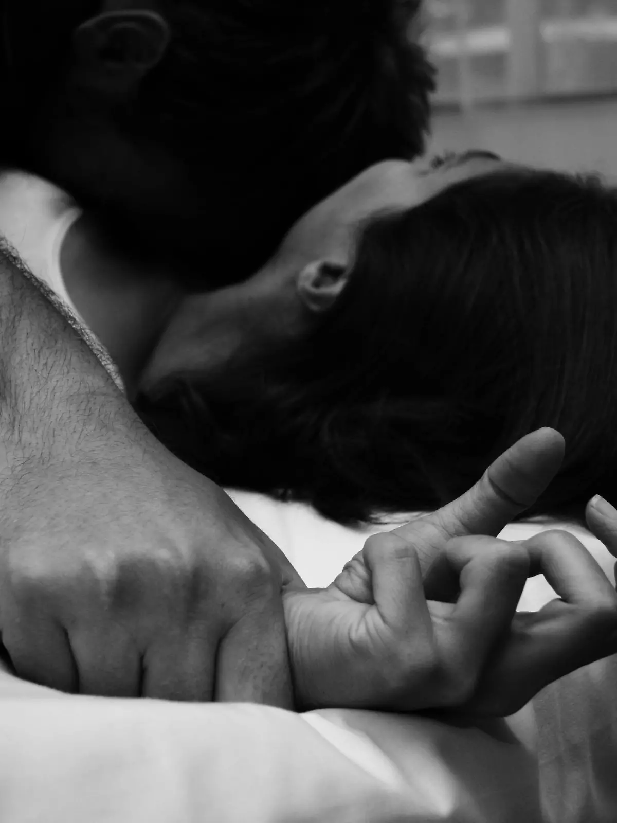 man pinning a woman to the bed