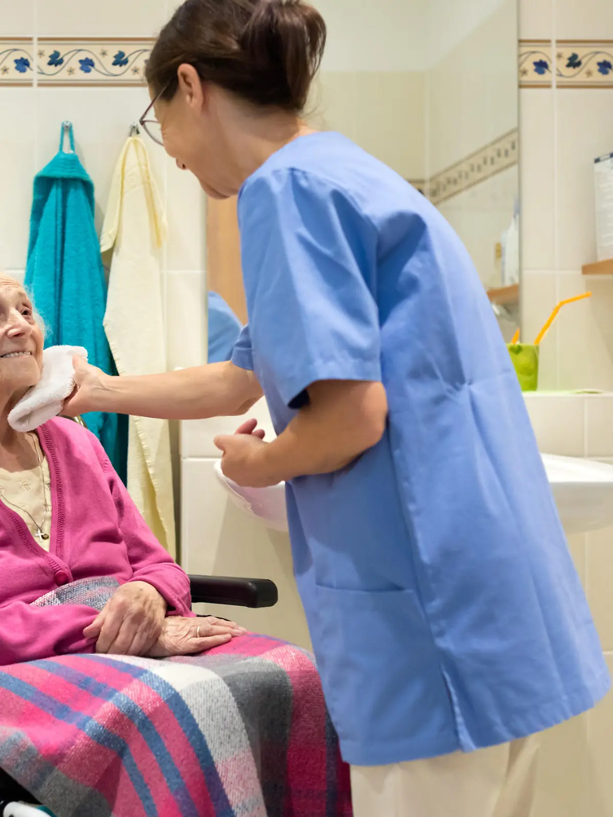 Eine Pflegekraft wäscht eine Patientin.