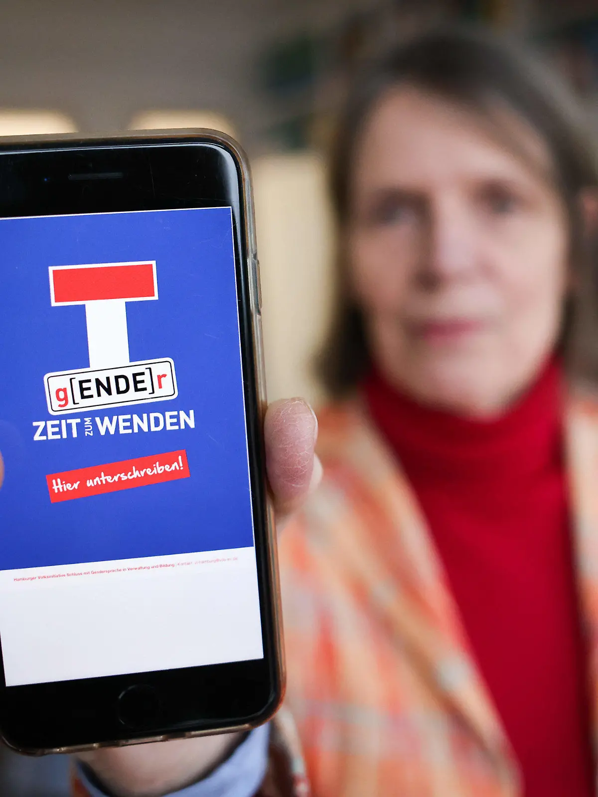 03.02.2023, Hamburg: Sabine Mertens, Bundesvorstand im Verein Deutsche Sprache, hält ihr Smartphone mit einem Plakatentwurf einer Volksinitiative gegen die Gendersprache in Verwaltung und Bildung. (zu dpa «Initiatoren wollen Hamburger Volksinitiative gegen Gendern anmelden») Foto: Christian Charisius/dpa - ACHTUNG: Nur zur redaktionellen Verwendung im Zusammenhang mit der aktuellen Berichterstattung +++ dpa-Bildfunk +++