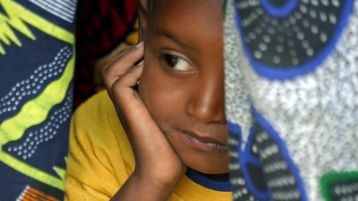 A young Senegalese girl under cover in her mother's traditional clothes, while they attend the official renouncement ceremony of Female Genital Cutting (FGC) at a ceremony in Kidira, eastern Senegal, Sunday 12 March 2006. The town of Kidira on the border with Mali, received representatives from 52 neighbouring villages from Senegal and Mali to publicly announce an end to the practice of Female Genital Cutting (FGC) and early marriage. It was the twentieth renouncement of such harmful practices for girls and women in Senegal. This area has a particularly high rate of FGC since the majority of the ethnic groups living there have practiced these traditions for centuries. One third out of 5,000 Senegalese villages have abandoned FGC since 1997. EPA/PIERRE HOLTZ +++(c) dpa - Report+++, A young Senegalese girl under cover in her mother's traditional clothes, while they attend the official renouncement ceremony of Female Genital Cutting (FGC) at a ceremony in Kidira, eastern Senegal, Sunday 12 March 2006. The town of Kidira on the border with Mali, received representatives from 52 neighbouring villages from Senegal and Mali to publicly announce an end to the practice of Female Genital Cutting (FGC) and early marriage. It was the twentieth renouncement of such harmful practices for girls and women in Senegal. This area has a particularly high rate of FGC since the majority of the ethnic groups living there have practiced these traditions for centuries. One third out of 5,000 Senegalese villages have abandoned FGC since 1997. EPA/PIERRE HOLTZ +++(c) dpa - Report+++