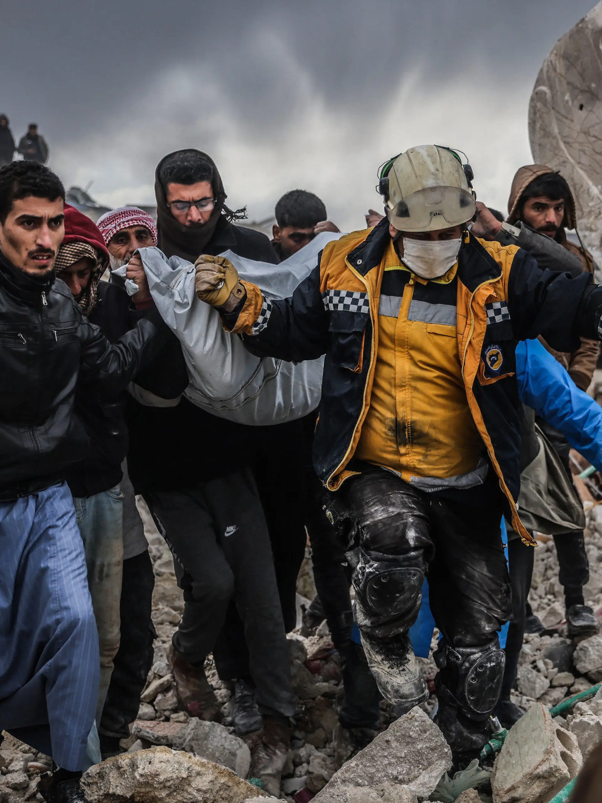 06.02.2023, Syrien, Harem: Zivilisten und Mitglieder des syrischen Zivilschutzes führen Such- und Rettungsmaßnahmesuchen in den Trümmern eines zerstörten Gebäudes durch. In der Türkei und in Syrien sind infolge der starken Erdbeben mindestens 2300 Menschen getötet worden. Foto: Anas Alkharboutli/dpa +++ dpa-Bildfunk +++