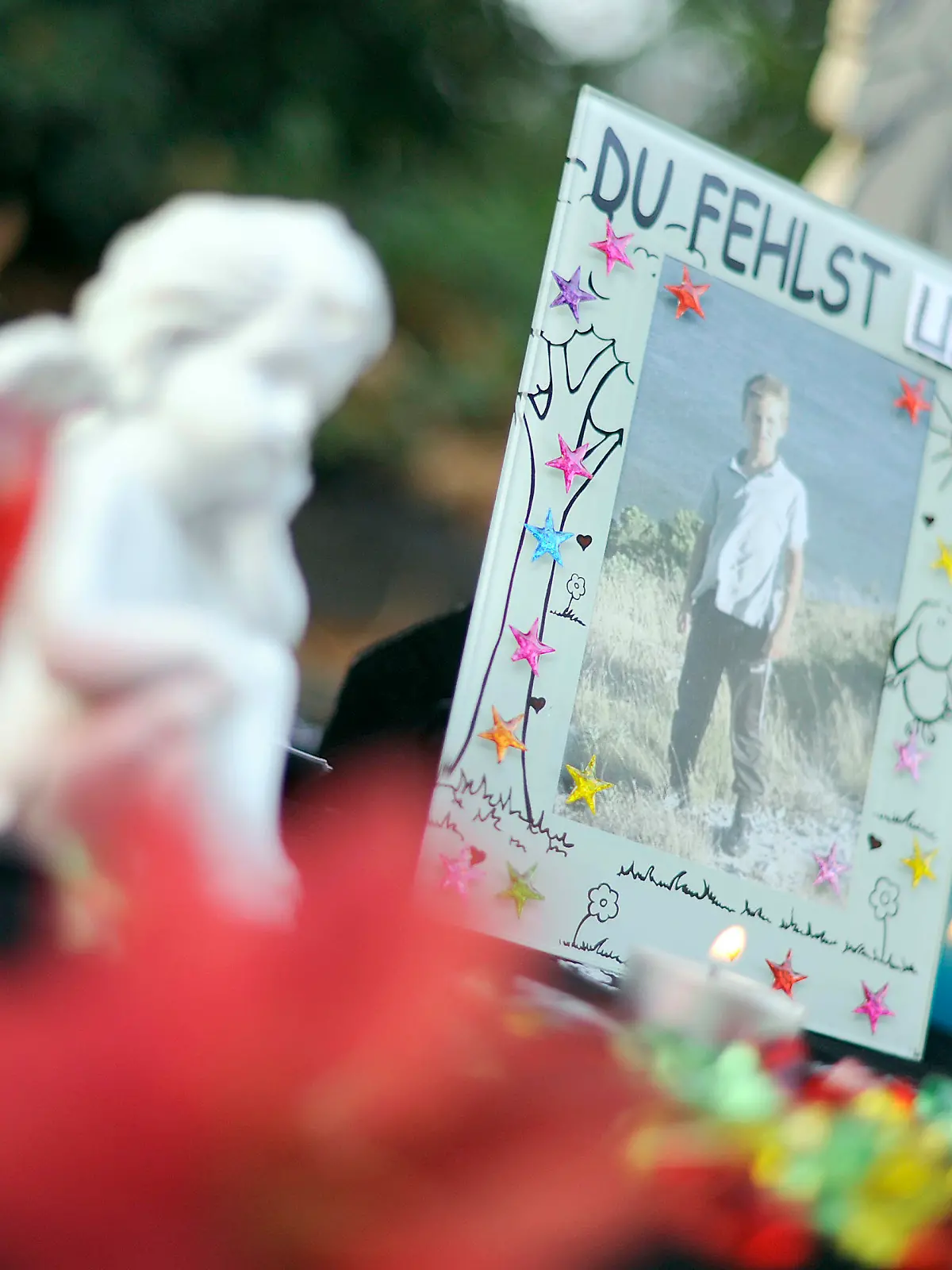 Kerzen und ein Foto des getöteten Mirco aus Grefrath stehen am Dienstag (12.07.2011) vor dem Landgericht in Krefeld. Vor dem Landgericht beginnt am Dienstag der Prozess gegen den mutmaßlichen Mörder des kleinen Mirco aus Grefrath. Der Angeklagte hat gestanden, den zehnjährigen Jungen getötet zu haben. Mirco war im September 2010 auf dem Heimweg verschwunden, nach 145 Tagen wurde er tot gefunden. Foto: Marius Becker dpa/lnw  +++(c) dpa - Bildfunk+++