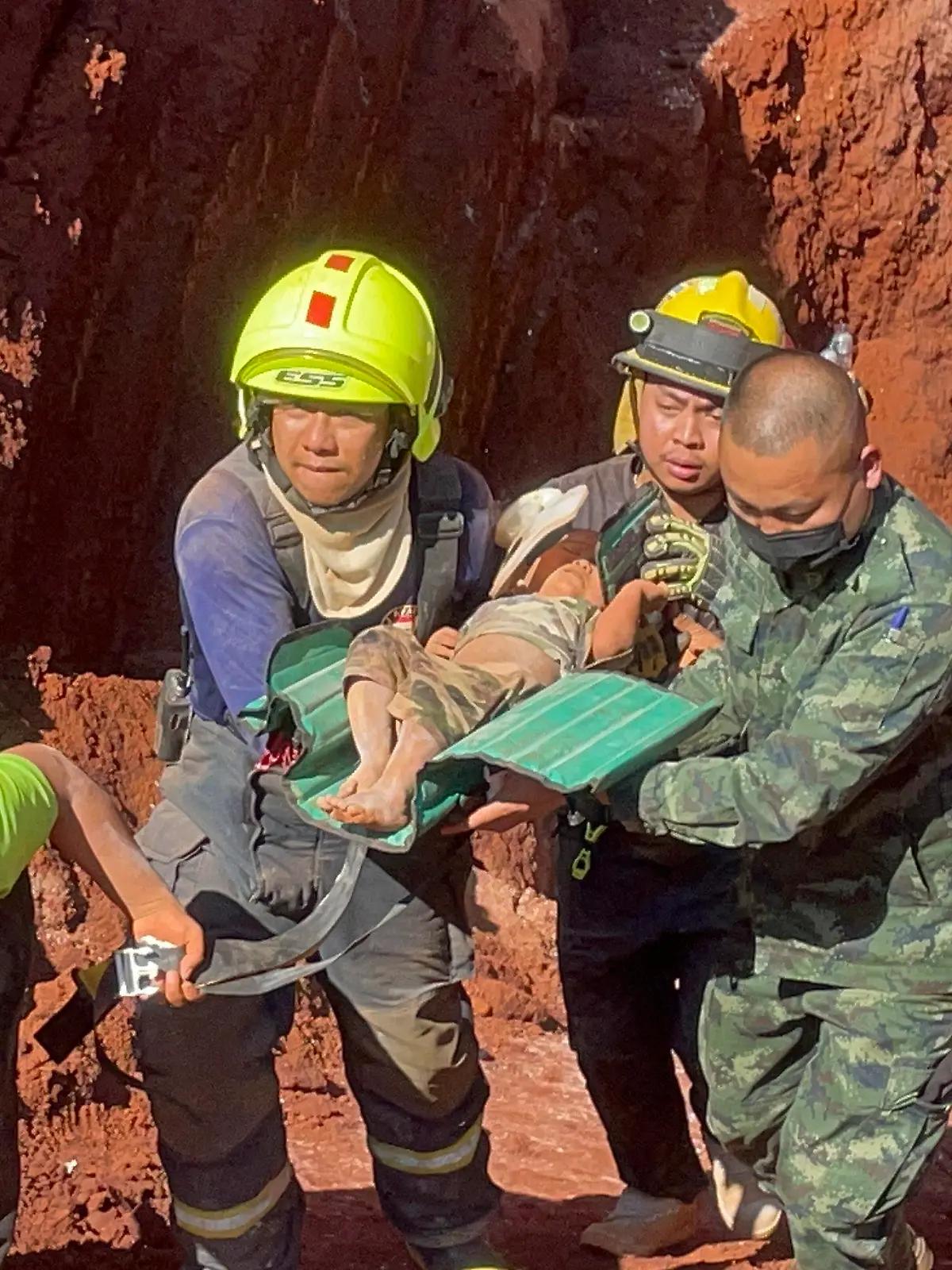07.02.2023, Thailand, Tak: Nach einer nächtlichen Rettungsaktion tragen Rettungskräfte und Militärs ein einjähriges Kind aus einem tiefen Loch in der nordthailändischen Provinz Tak, 420 km nördlich von Bangkok. Das aus Myanmar stammende Kleinkind war gestern Abend in das 15 Meter tiefe Loch gefallen, das für Grundwasserleitungen genutzt wird. Foto: Chiravuth Rungjamratratsami/AP/dpa +++ dpa-Bildfunk +++