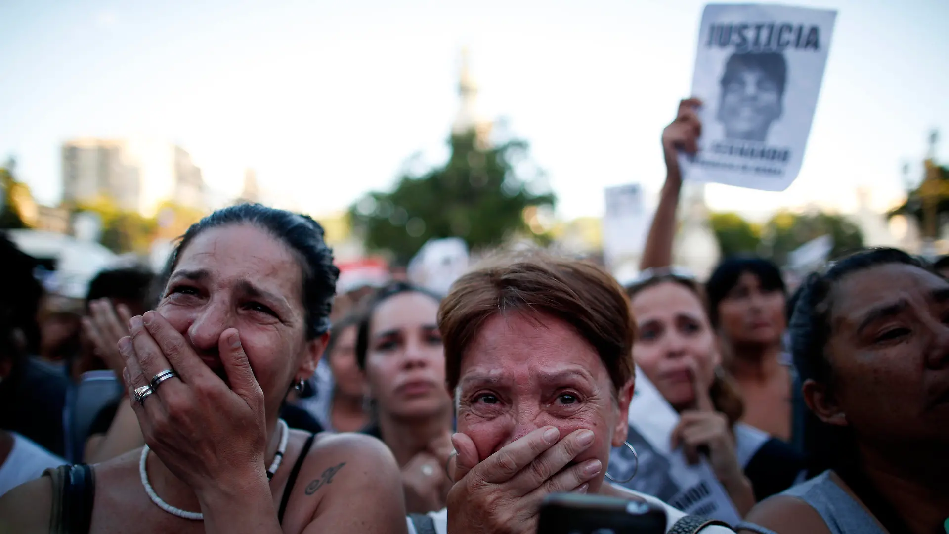Women cry outside Congress demanding justice for Fernando Baez Sosa during a protest outside Congress one month after the 18-year-old's death, in Buenos Aires, Argentina, Tuesday, Feb. 18, 2020. According to an attorney on the case, Baez Sosa was beaten to death by a group of rugby players in the coastal city of Villa Gesell, about 370 kilometers south of Buenos Aires. (AP Photo/Natacha Pisarenko)
